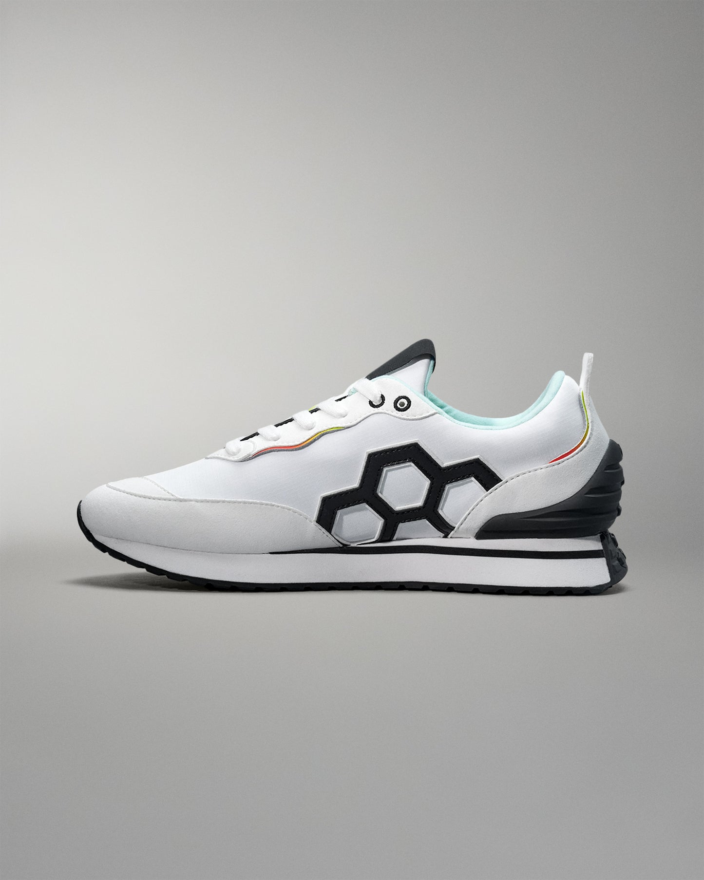 White sneaker with black geometric design on a gray background