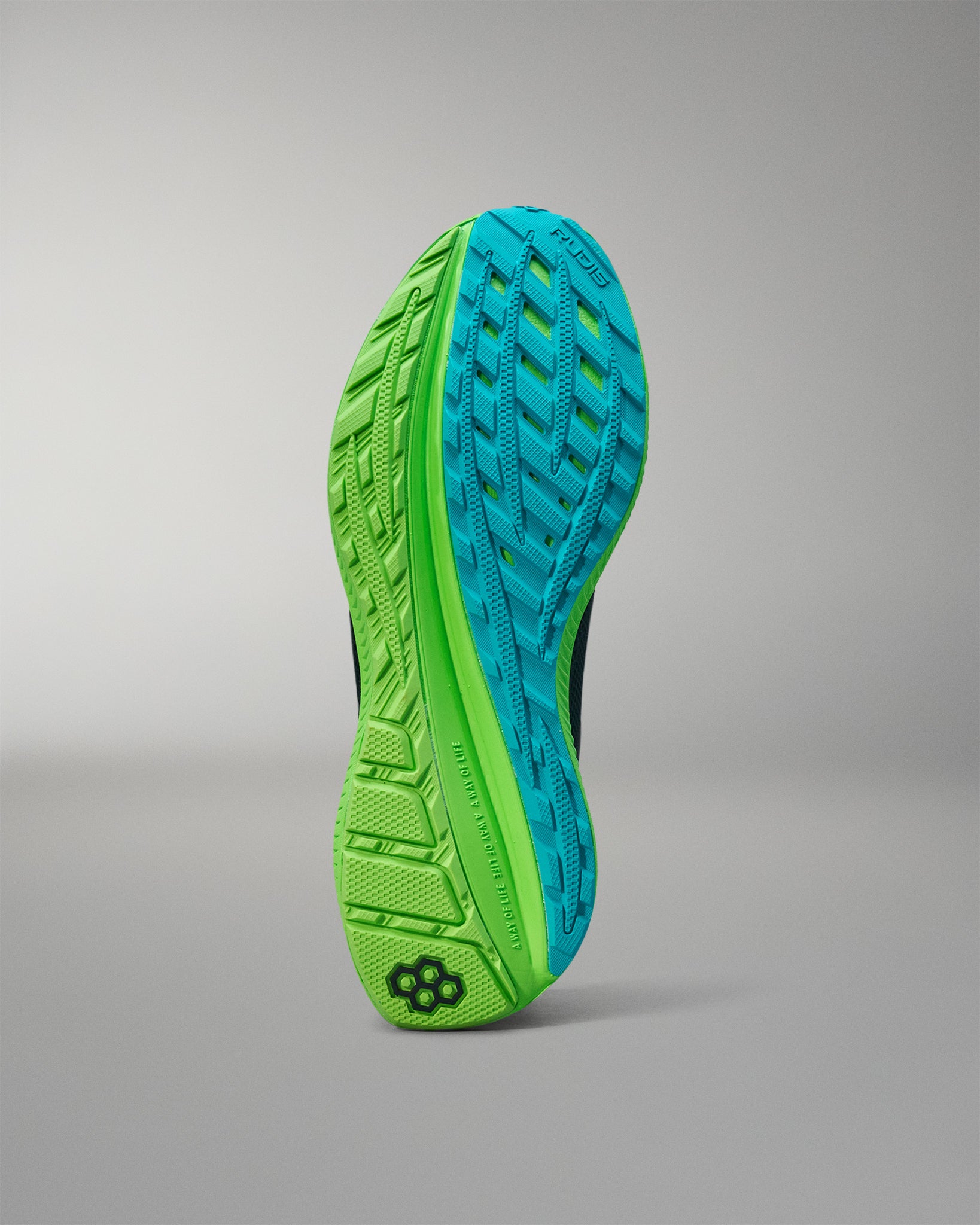 Close-up of a green and blue athletic shoe sole on a gray background