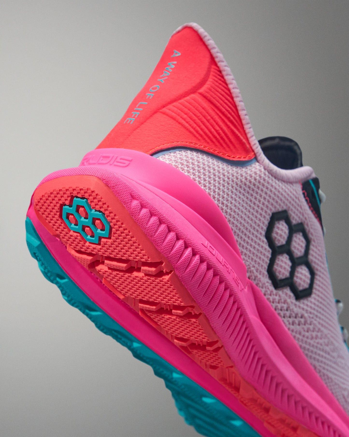 Close-up of a pink and orange running shoe with a gray background