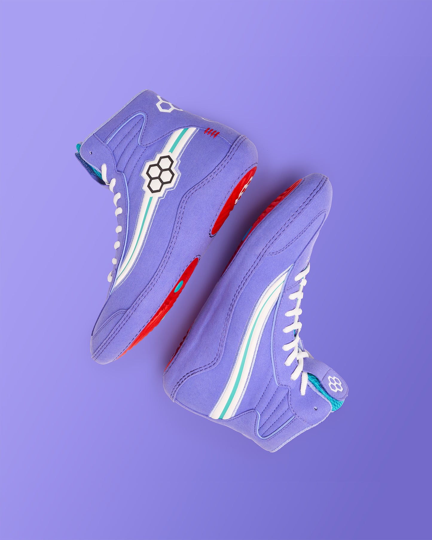 A pair of vibrant lavender high-top sneakers featuring bold red soles white laces and playful design accents