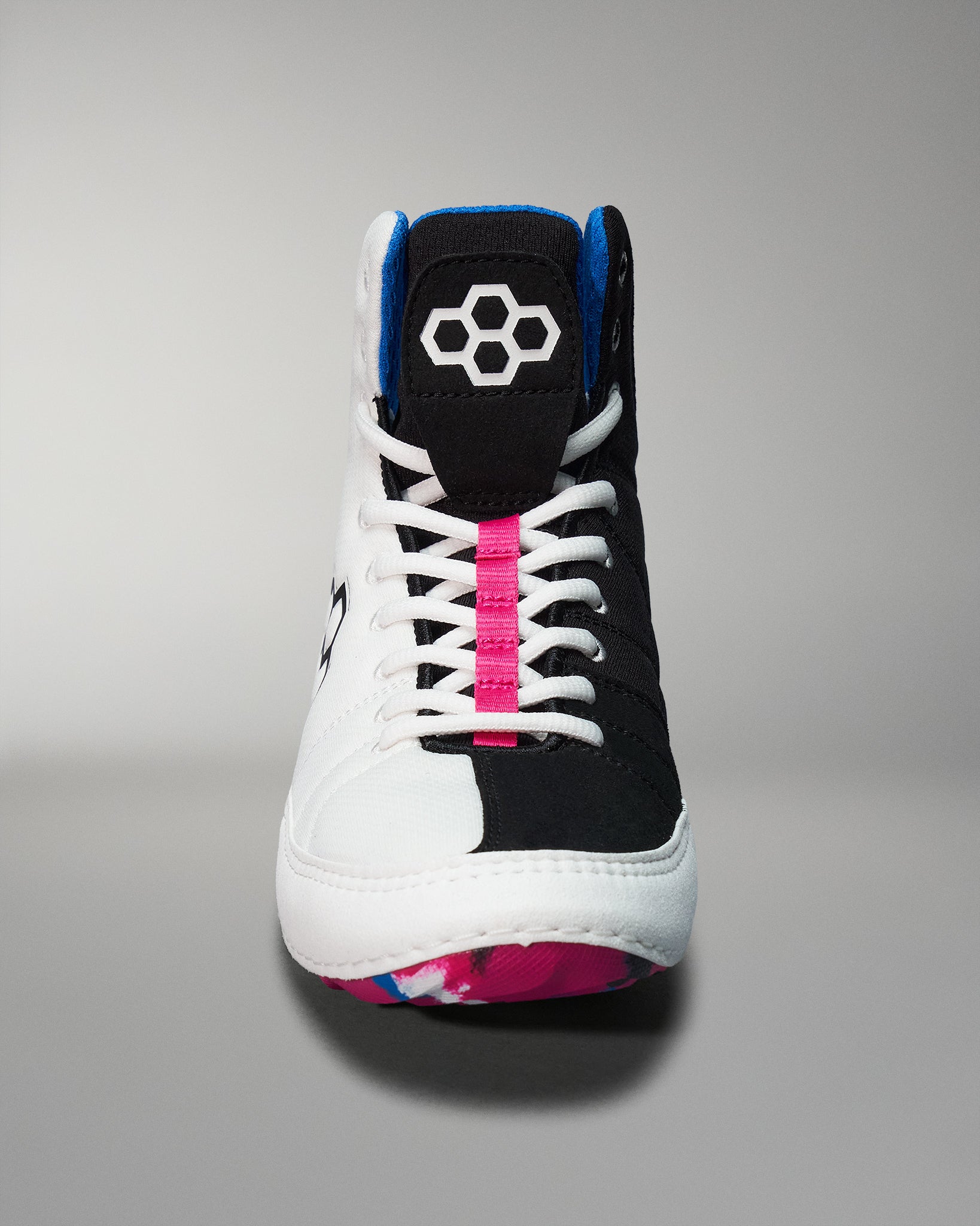 A front view of a high-top athletic shoe with a black and white design, highlighted by a pink stripe and a blue accent, featuring a patterned sole.