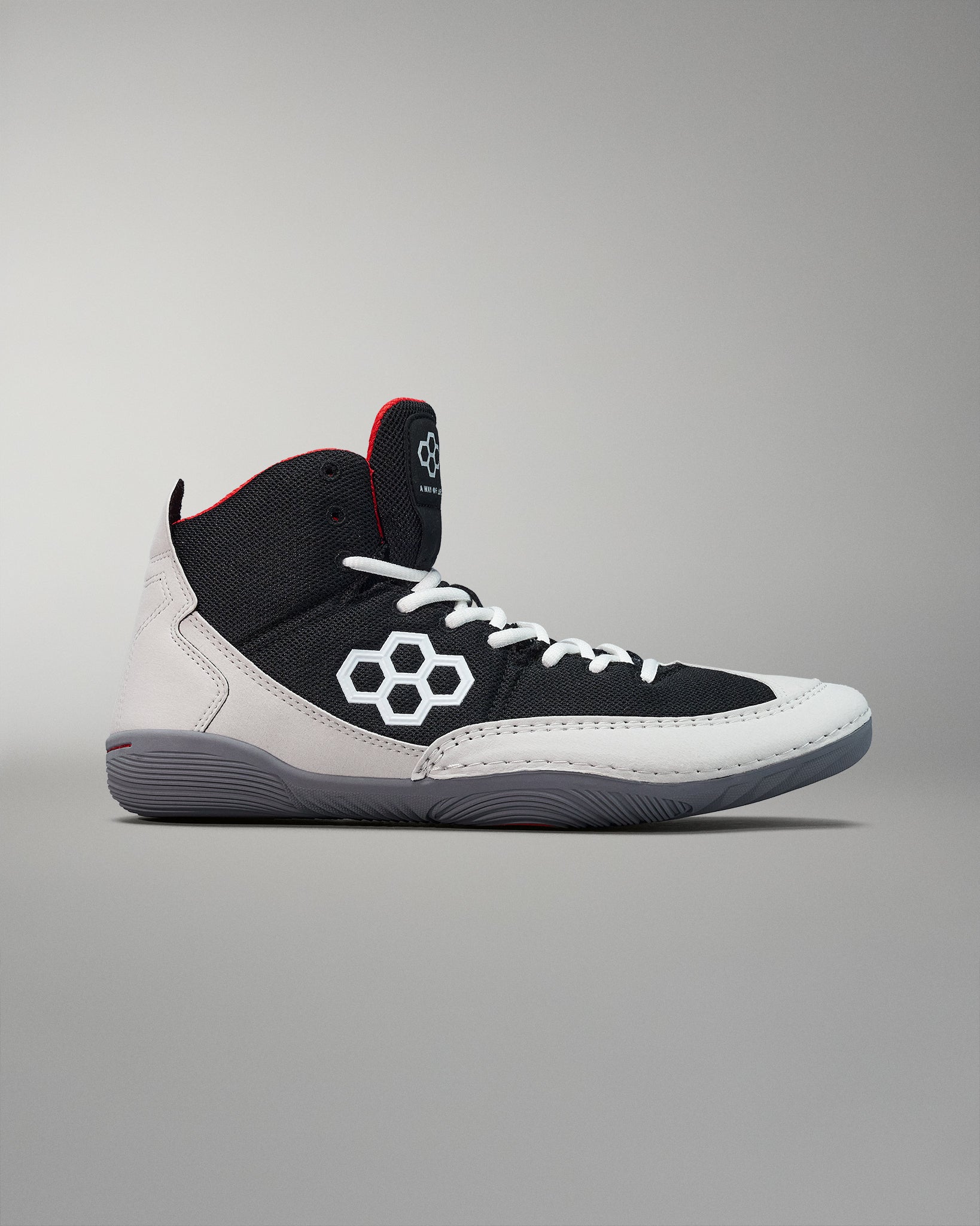 Side view - adult wrestling shoes with black, white, and red colors, featuring a micro-suede rand, and wrapped outsole.