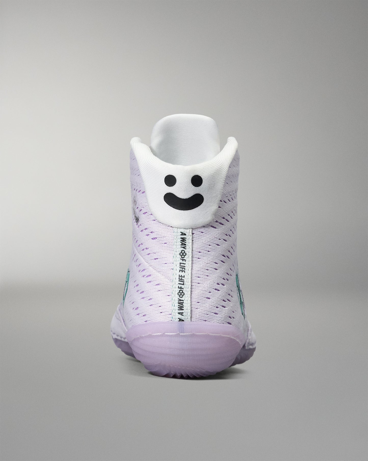 White sneaker with a smiley face design on a gray background