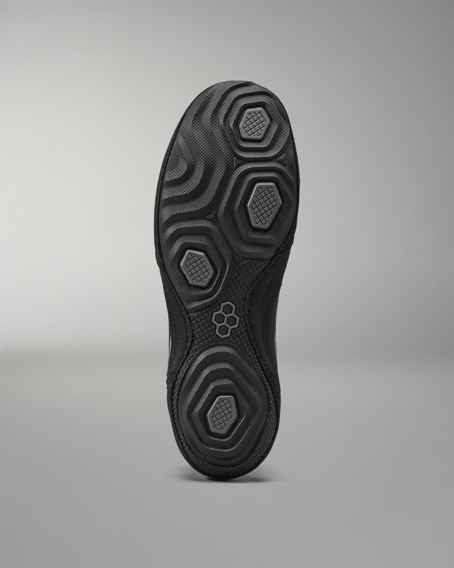Black Wrestling shoe sole with textured pattern on a gray background