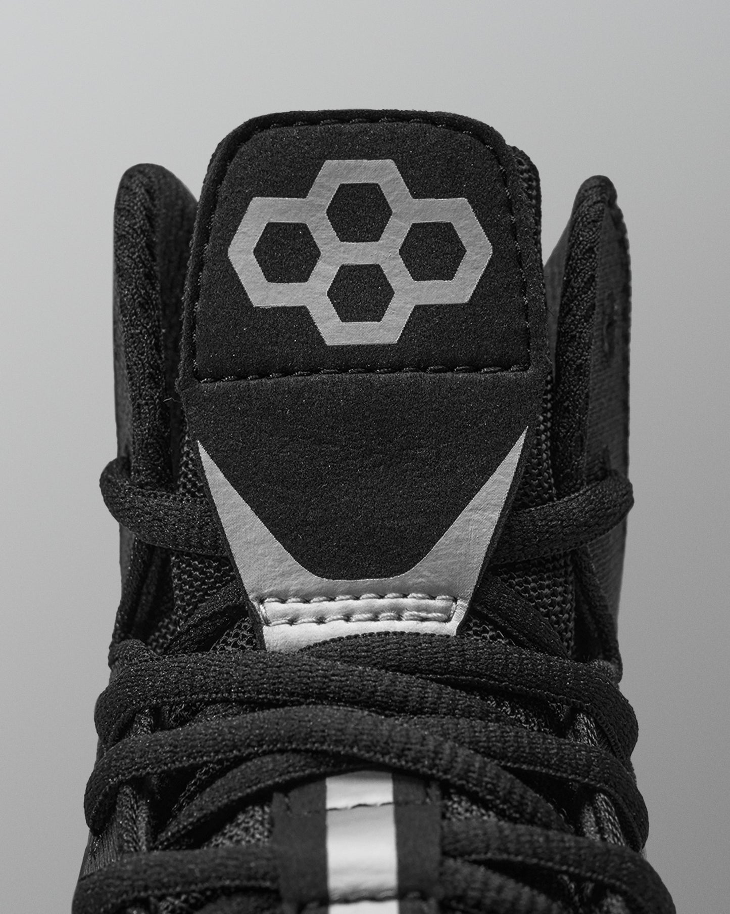 Black Wrestling shoe with a geometric logo on a gray background