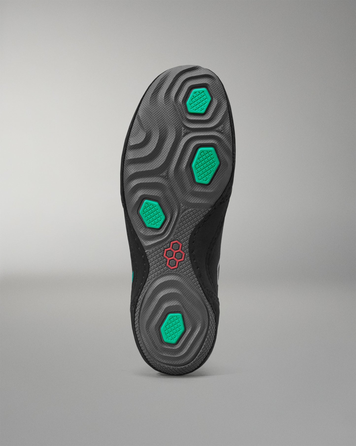 Black wrestling shoe sole with green hexagonal patterns on a gray background