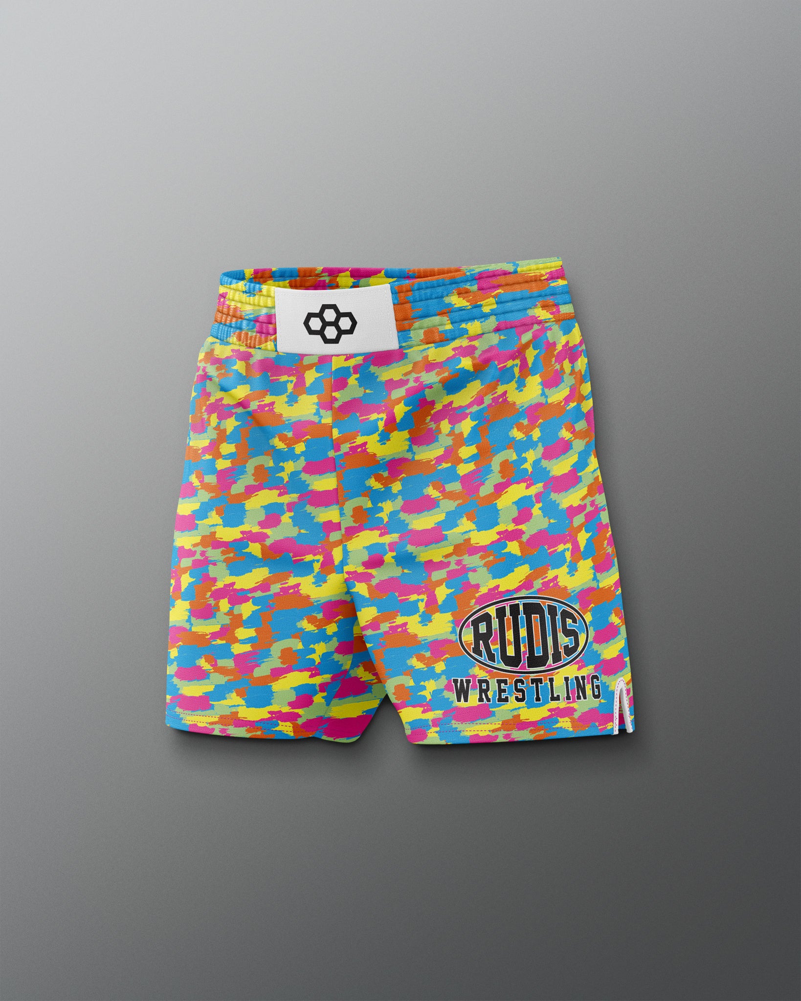 Colorful camouflage wrestling shorts with visible branding on a gray background