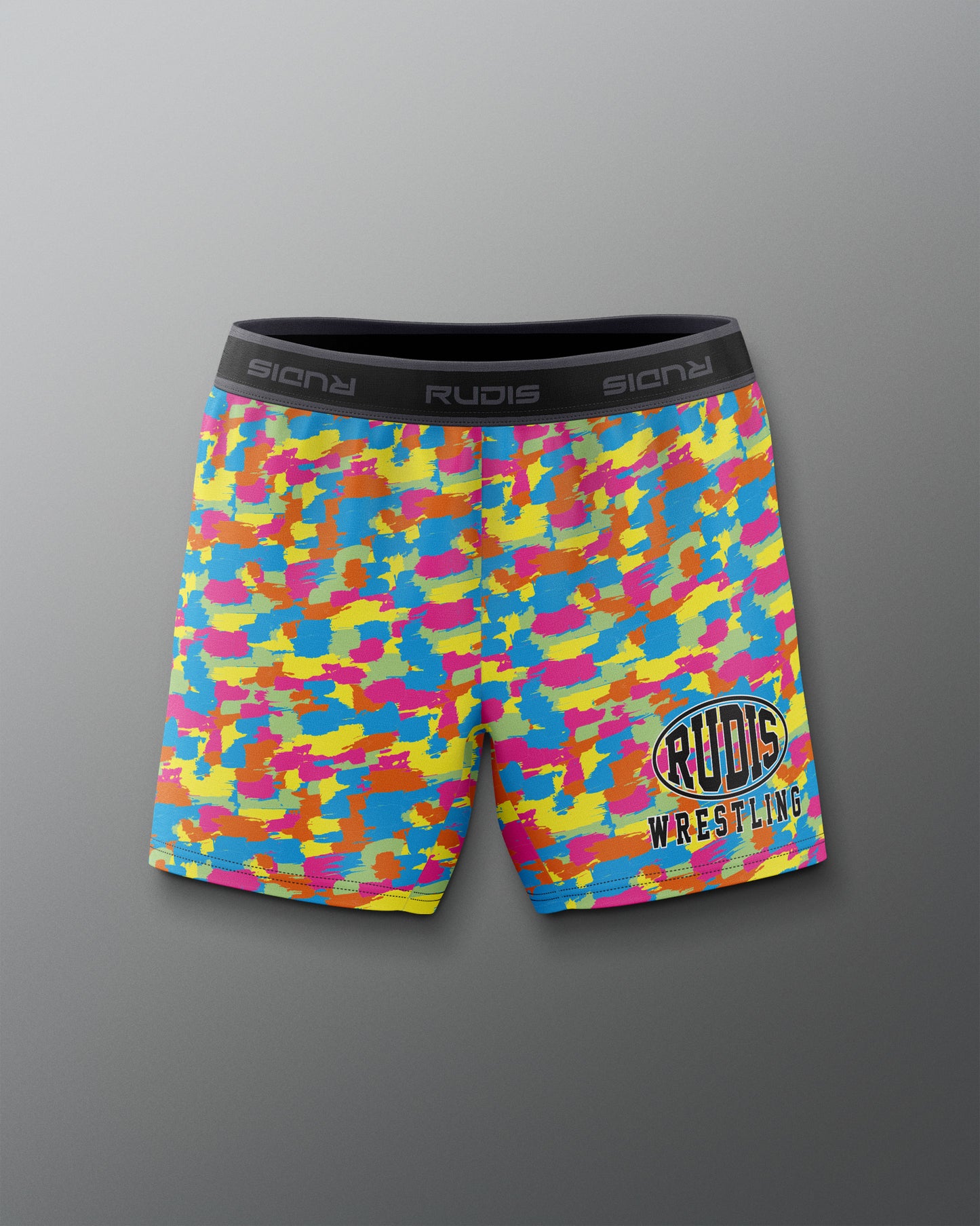 Colorful camouflage athletic shorts with 'Rudis Wrestling' logo on a gray background