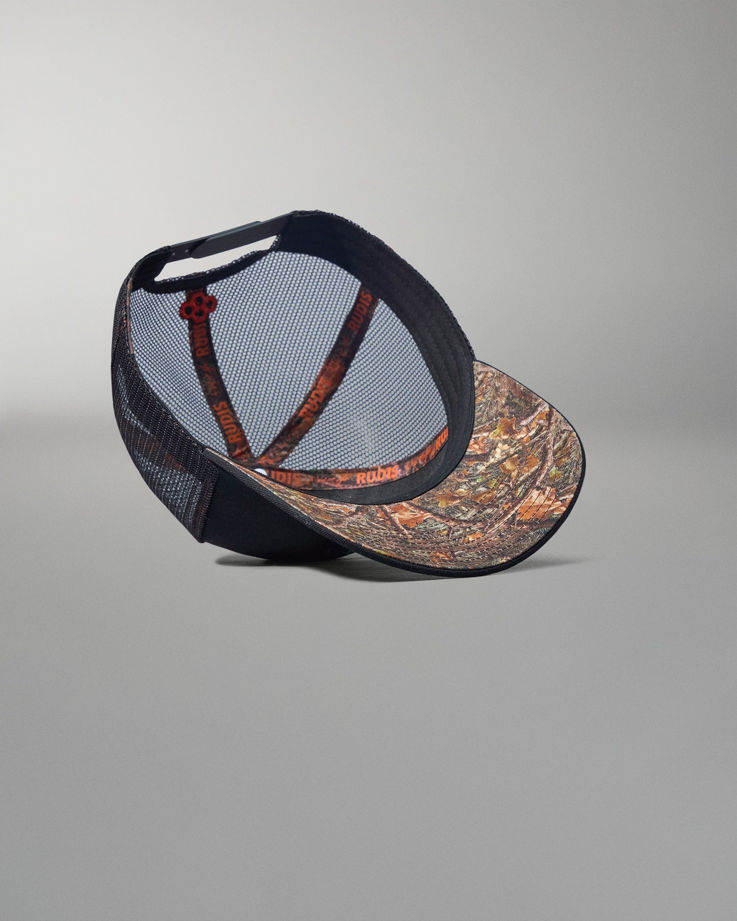 Cap with camouflage front and black mesh back on a gray background
