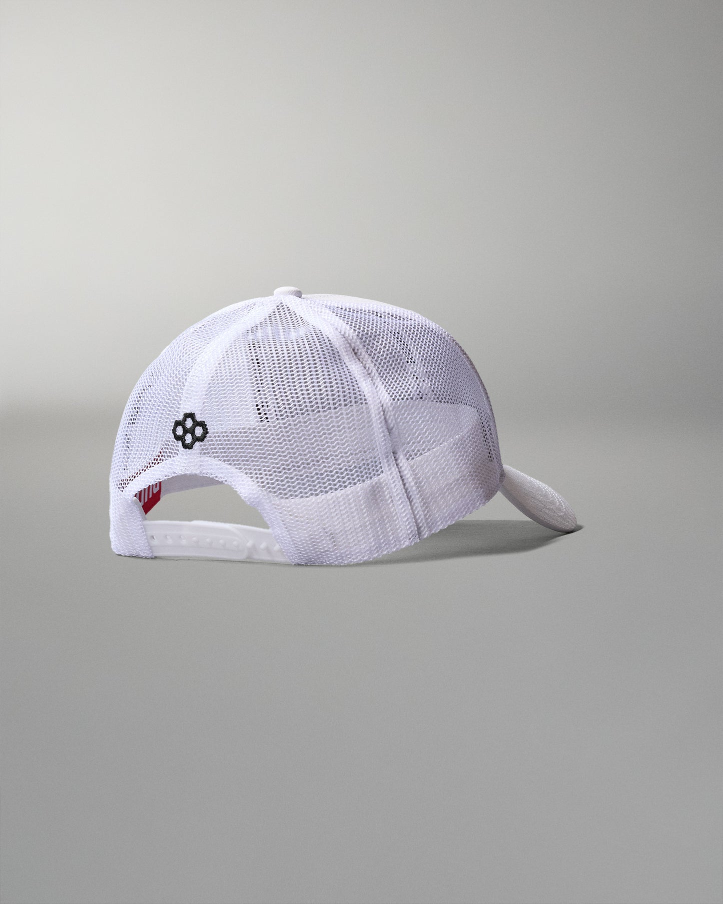White mesh cap with a small logo on a gray background