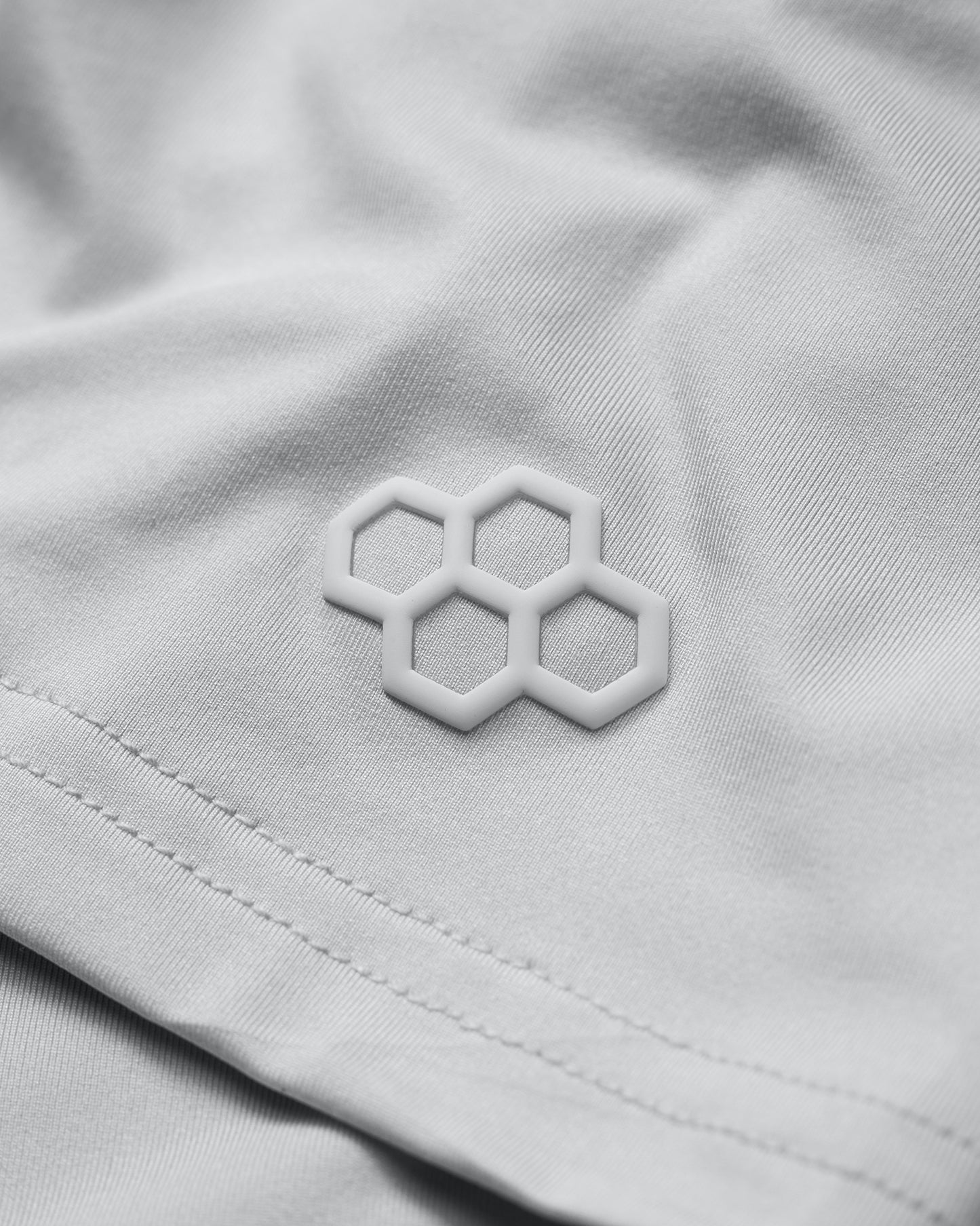 Close-up of a light gray fabric with a geometric logo.