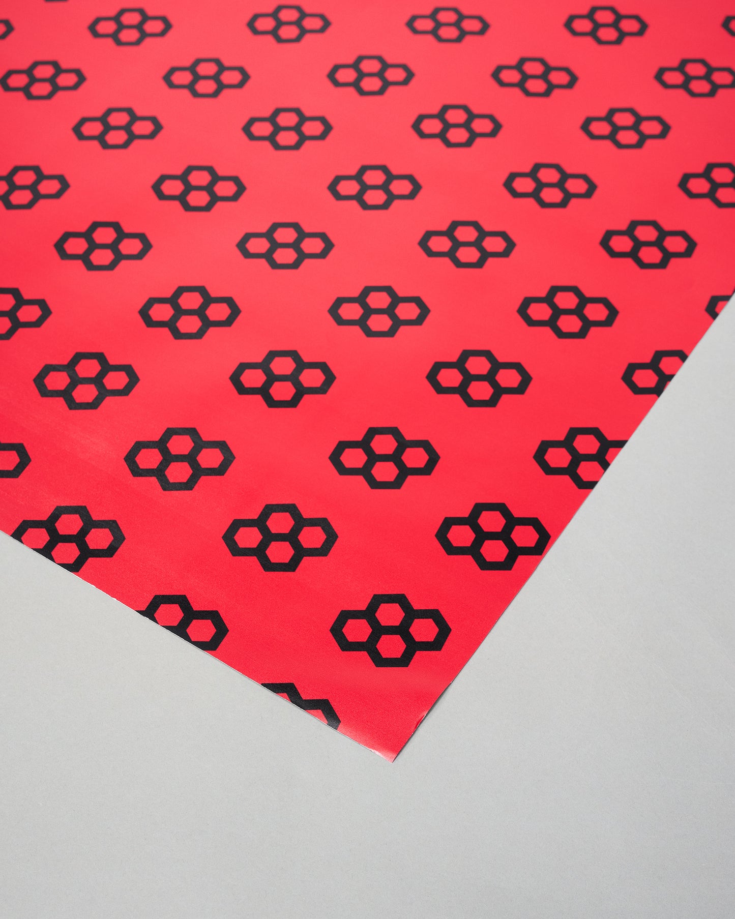 Red paper with black geometric pattern on a gray background