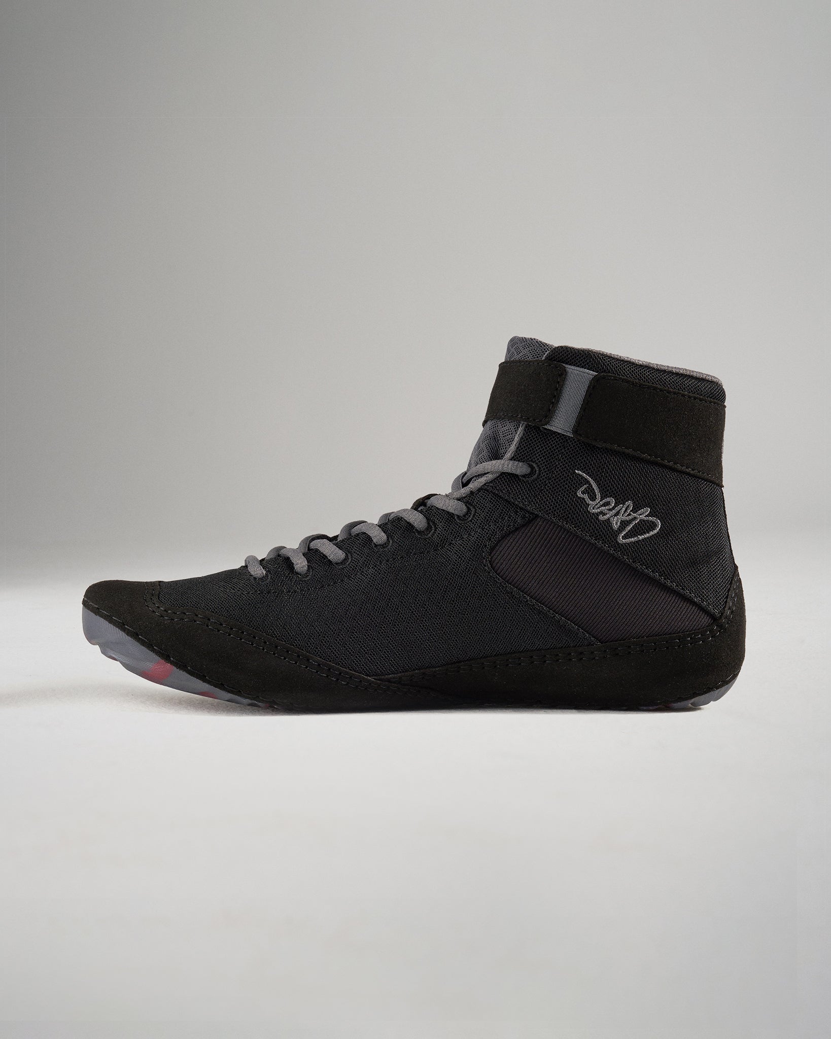 A sleek black wrestling shoe with a high-top design featuring a breathable mesh upper and a textured sole for optimal grip