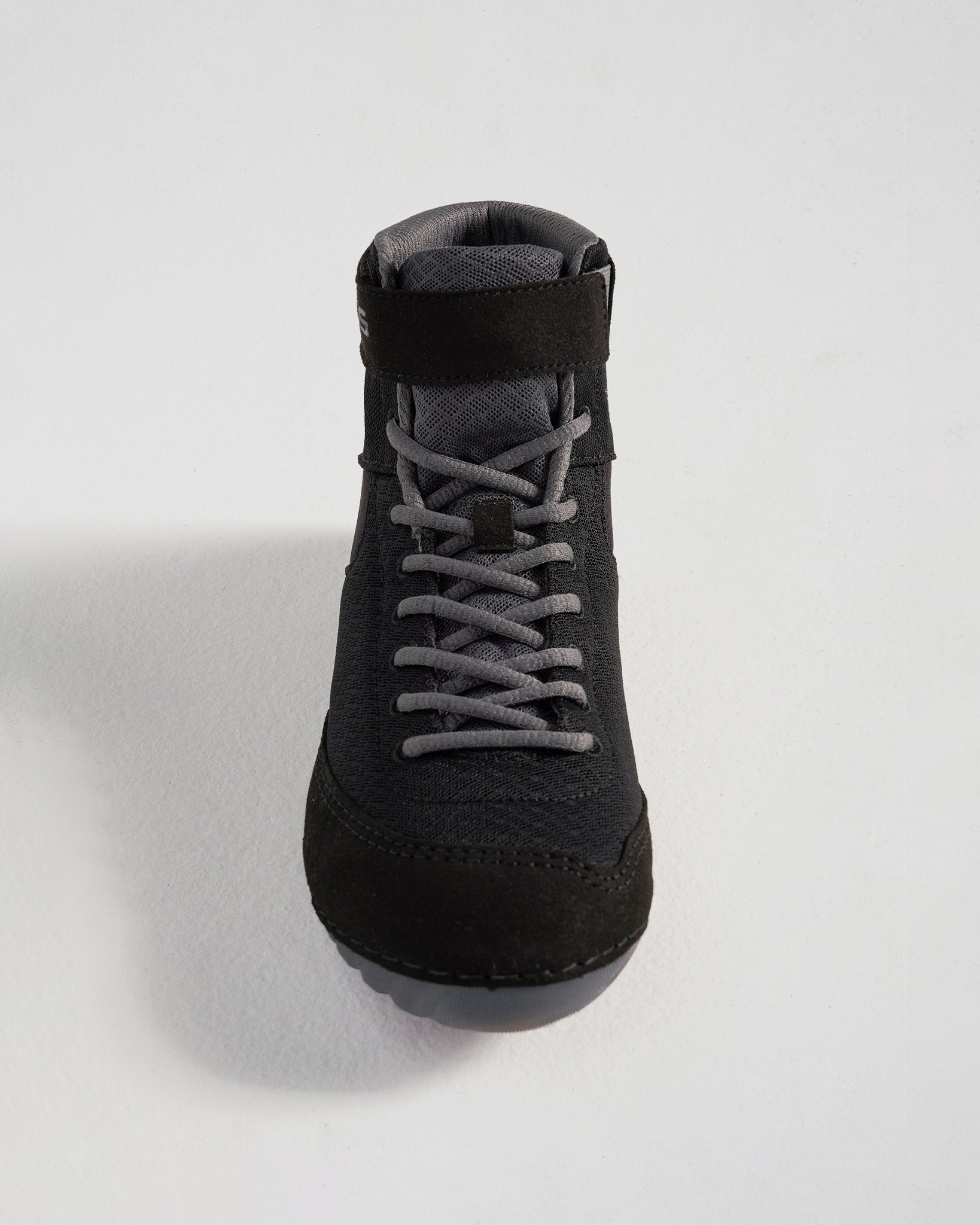 A top-down view of a stylish black shoe featuring a combination of mesh and suede materials designed for comfort and performance