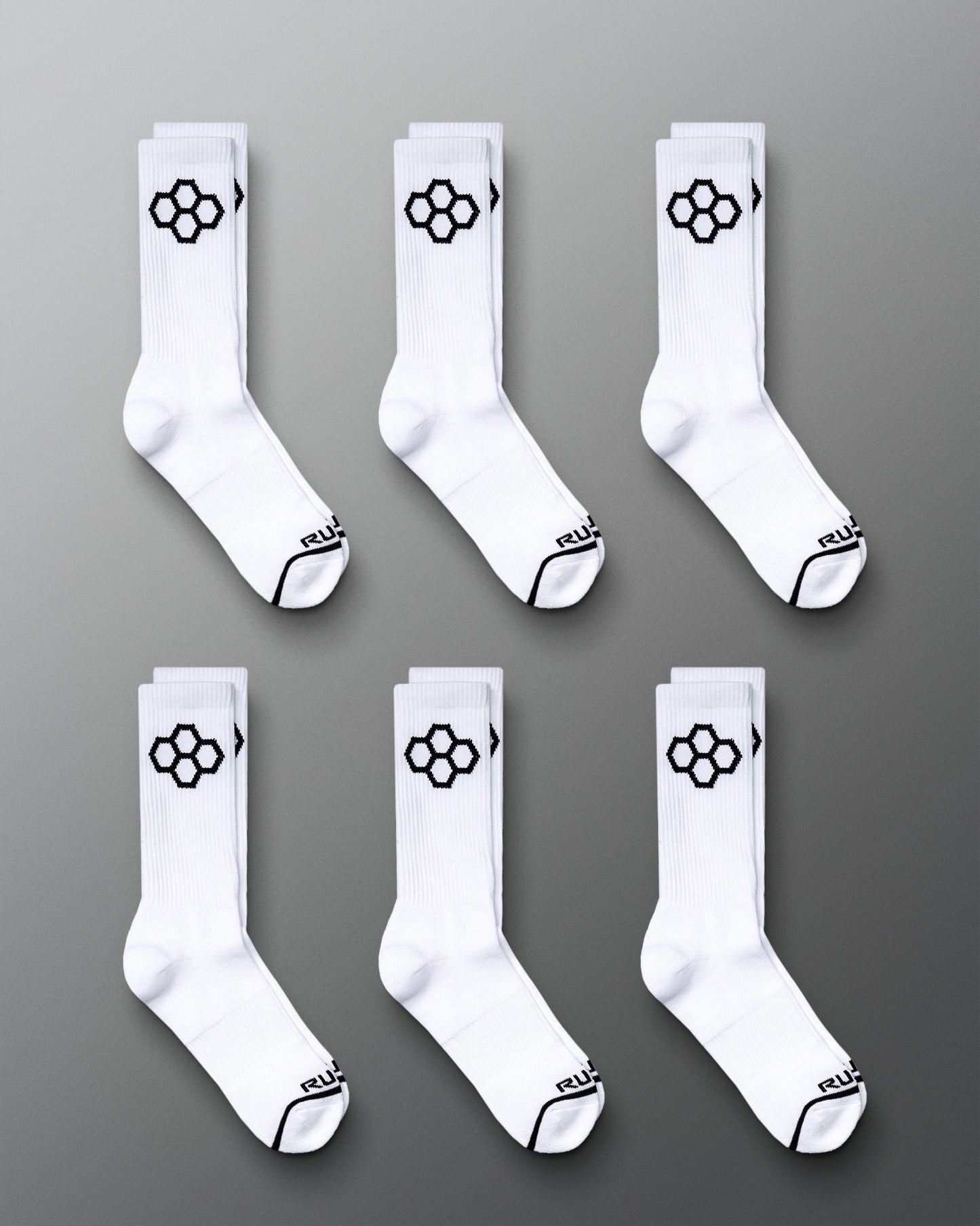 This image displays six pairs of white sports socks featuring a distinctive black hexagonal logo on the sides and black accents on the toes