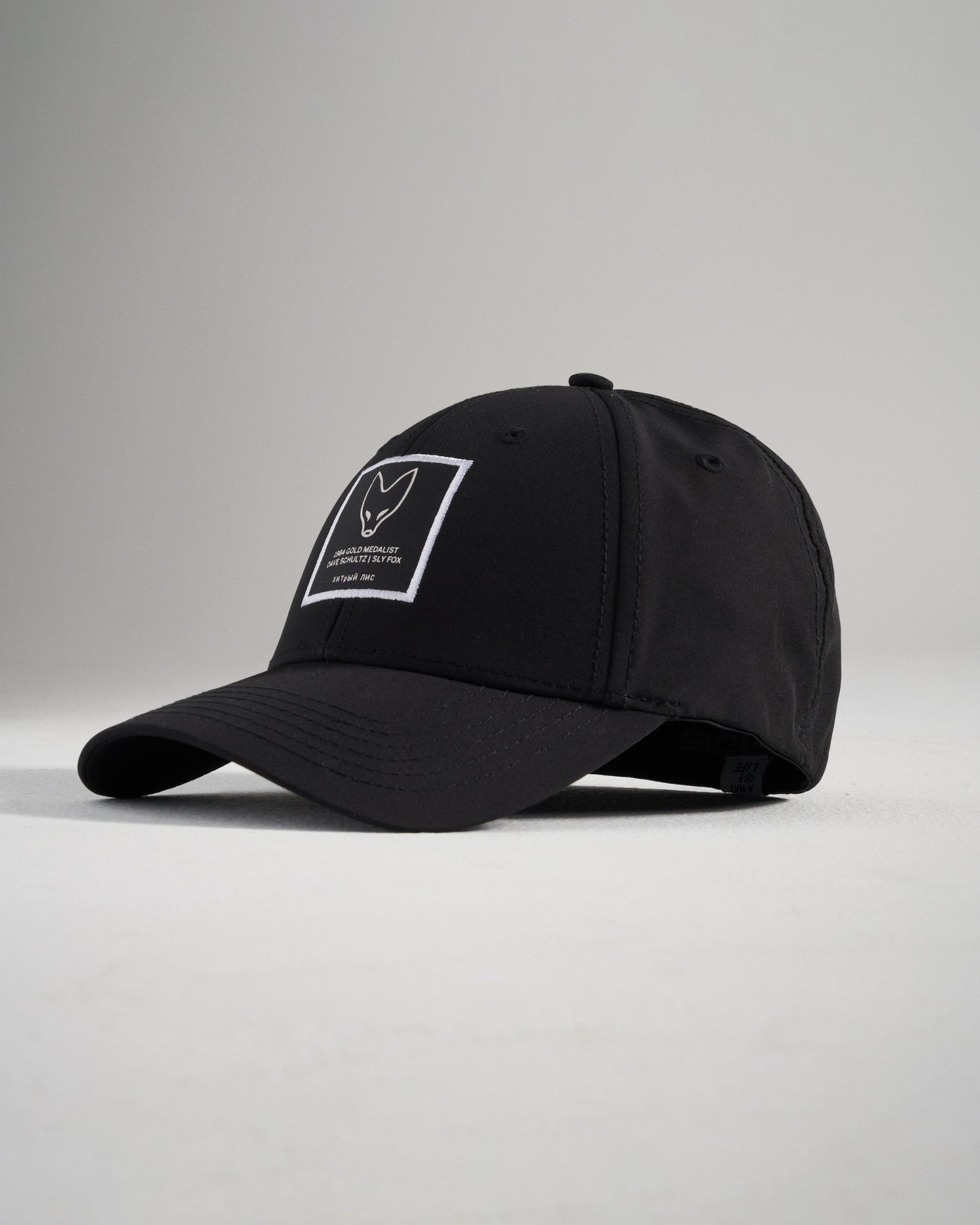 A stylish black cap featuring a minimalistic design with a logo patch on the front and a curved brim