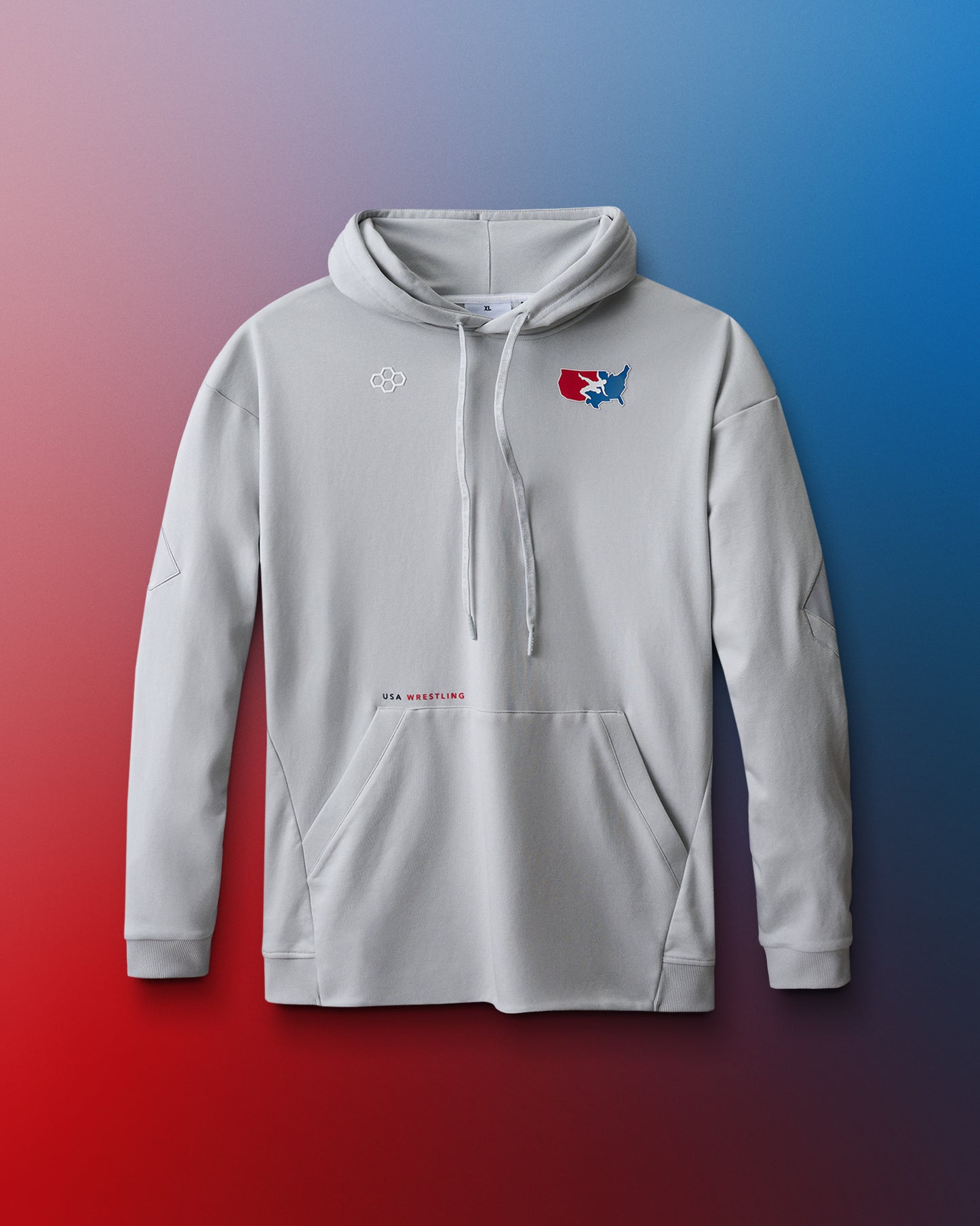 A light gray pullover hoodie displayed against a red-to-blue gradient background. The hoodie features a front kangaroo pocket, ribbed cuffs, and a drawstring hood. On the upper left chest, there's a small white hexagonal RUDIS logo. On the right chest, a red, white, and blue USA Wrestling logo shows a wrestler in action over a map of the United States. Below the pocket, centered on the lower torso, is small text reading "USA WRESTLING" in black and red font.