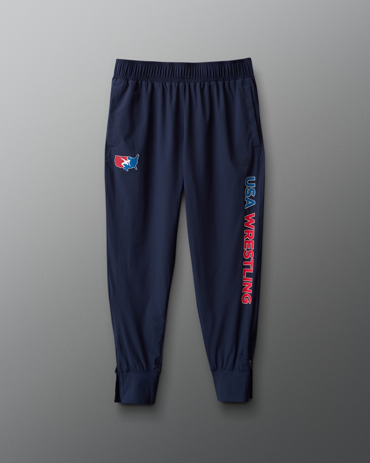 Navy blue sweatpants with USA Wrestling logo and text on a gray background
