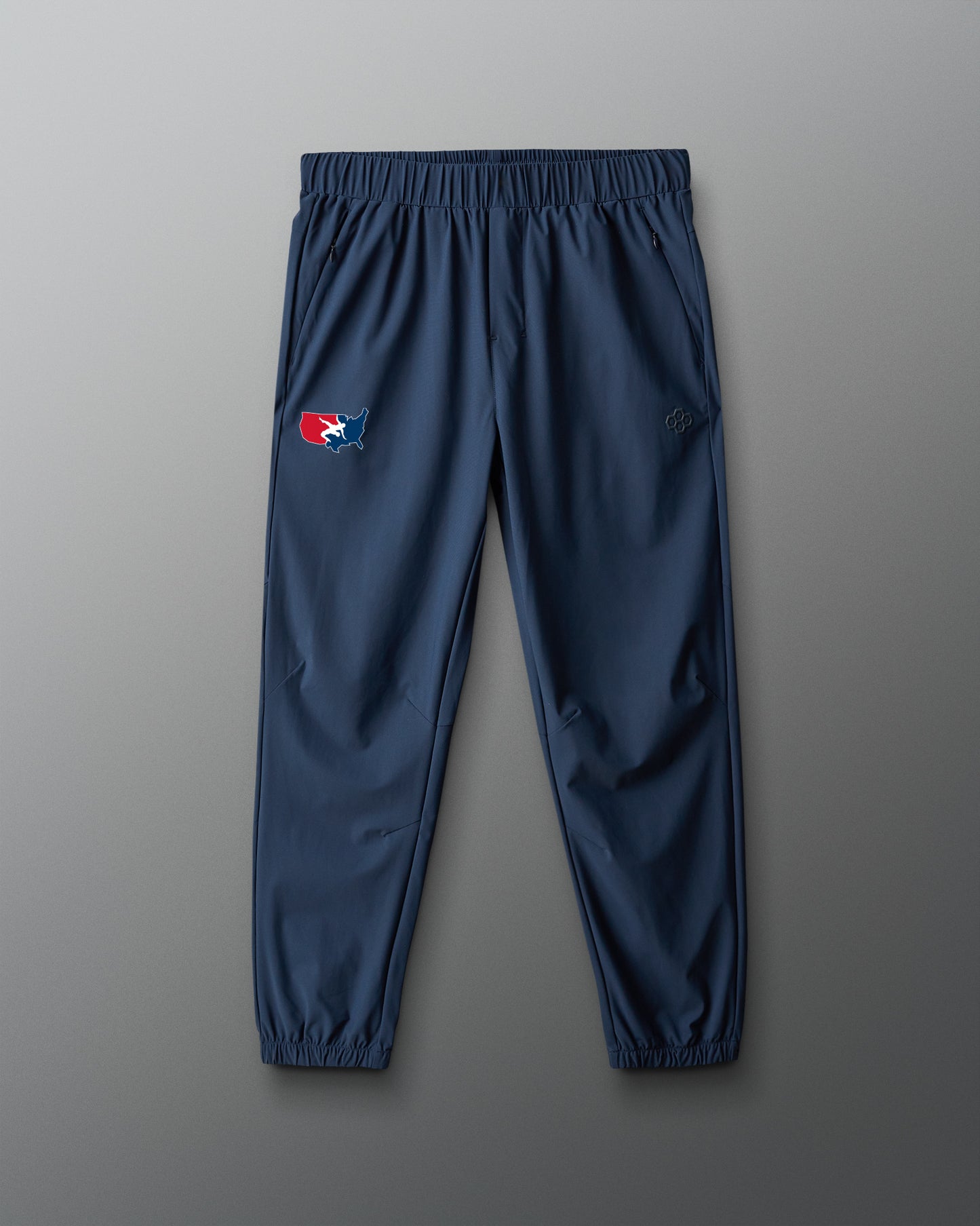 Navy blue sweatpants with a logo on a gray background