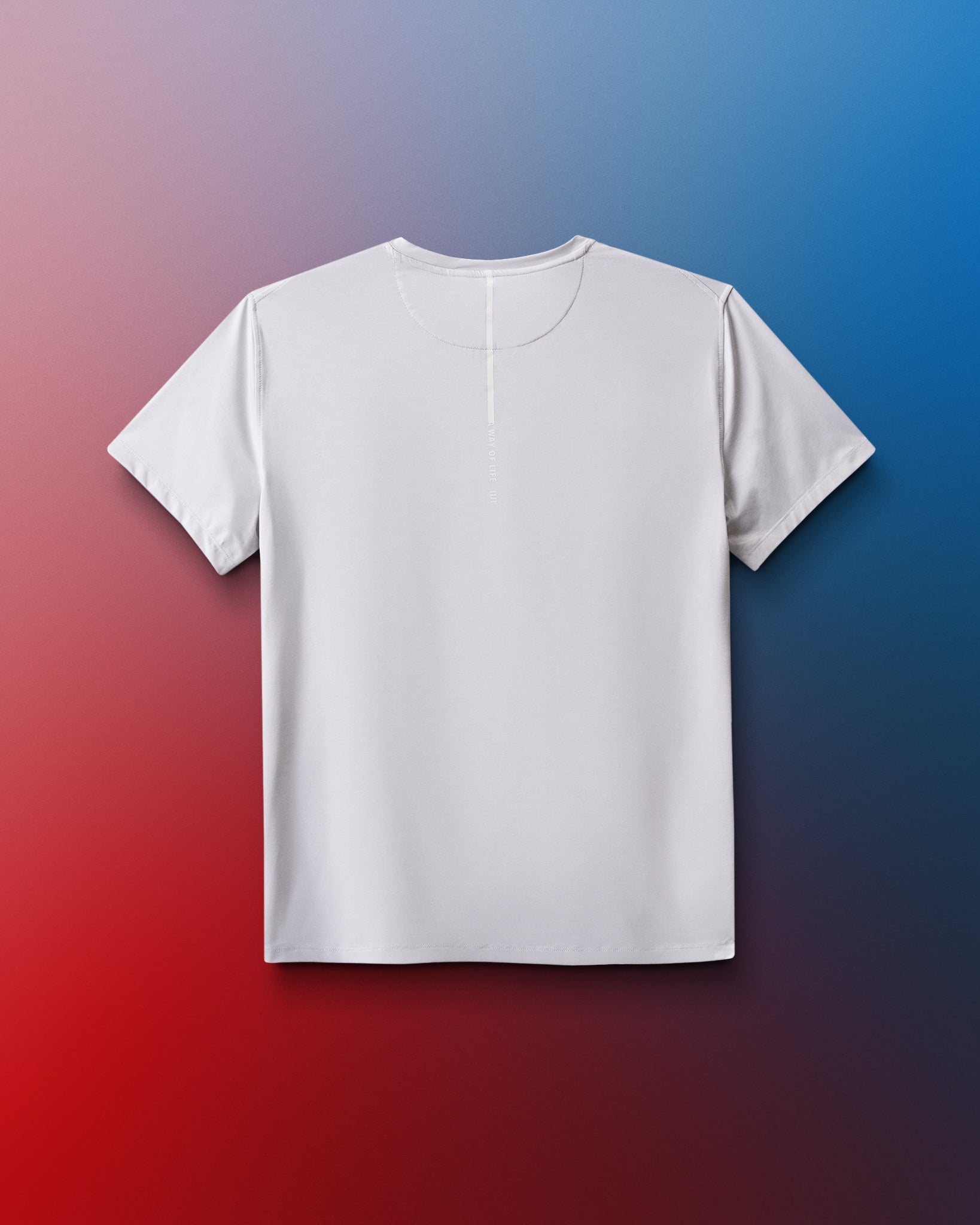 The back view of a white short-sleeve athletic T-shirt is shown against a red-to-blue gradient background. The shirt features a clean design with minimal seams and a subtle vertical stitched accent running from the collar to mid-back.