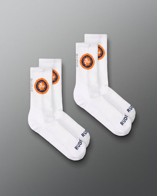 two white socks with orange and blue circular logos on a gray background