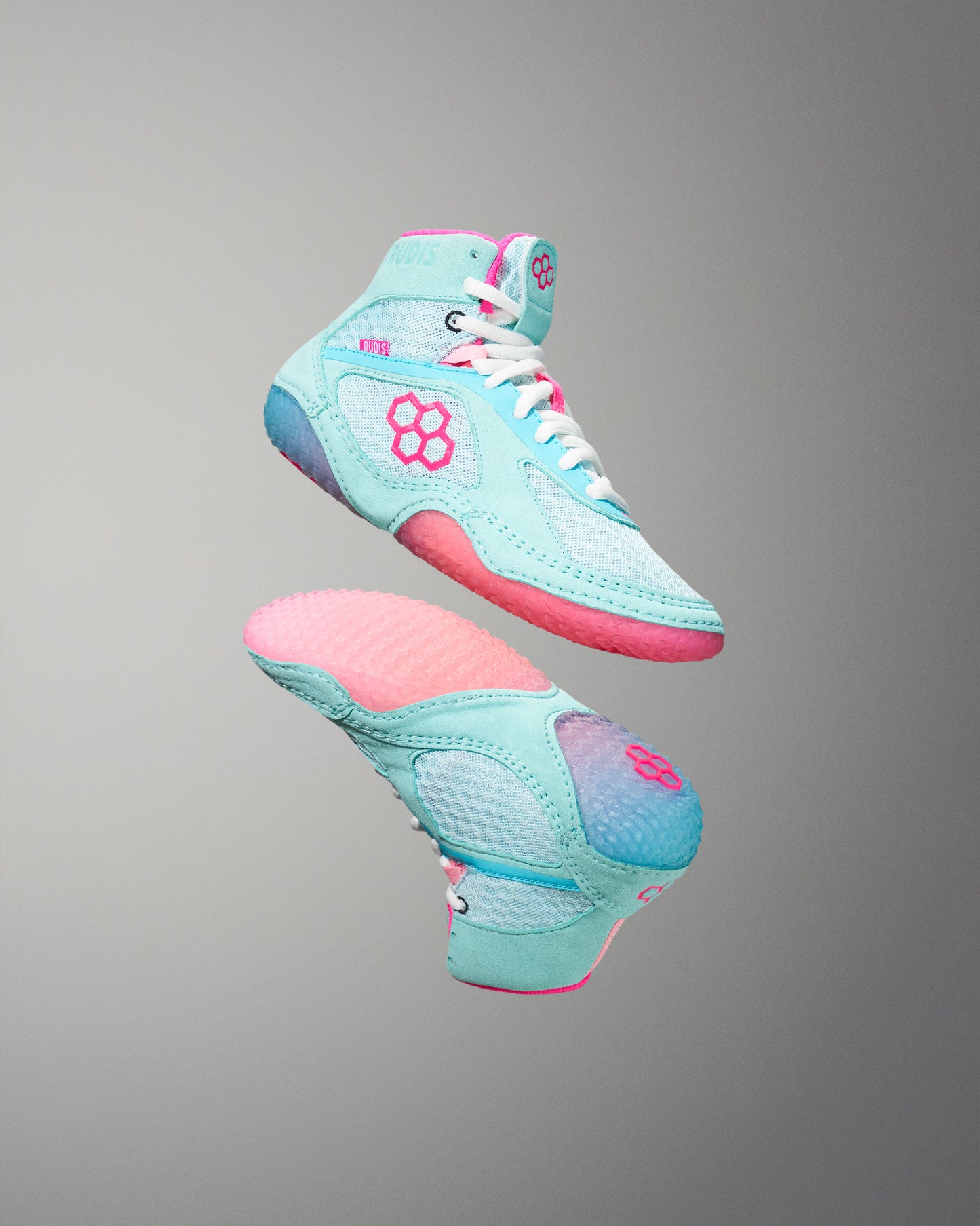 Pair of turquoise and pink high-top sneakers on a gray background
