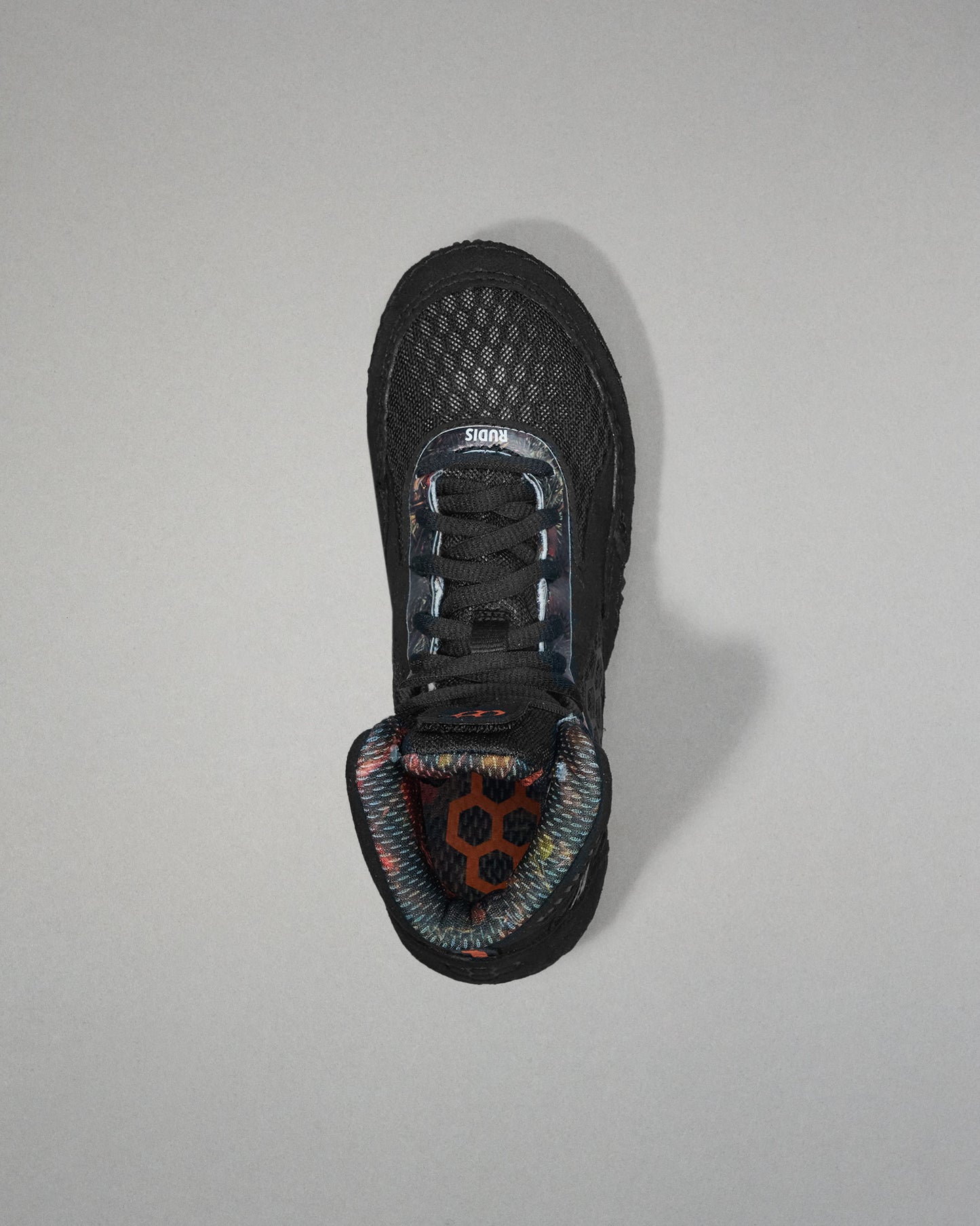 Black wrestling shoe with a unique sole design on a gray background