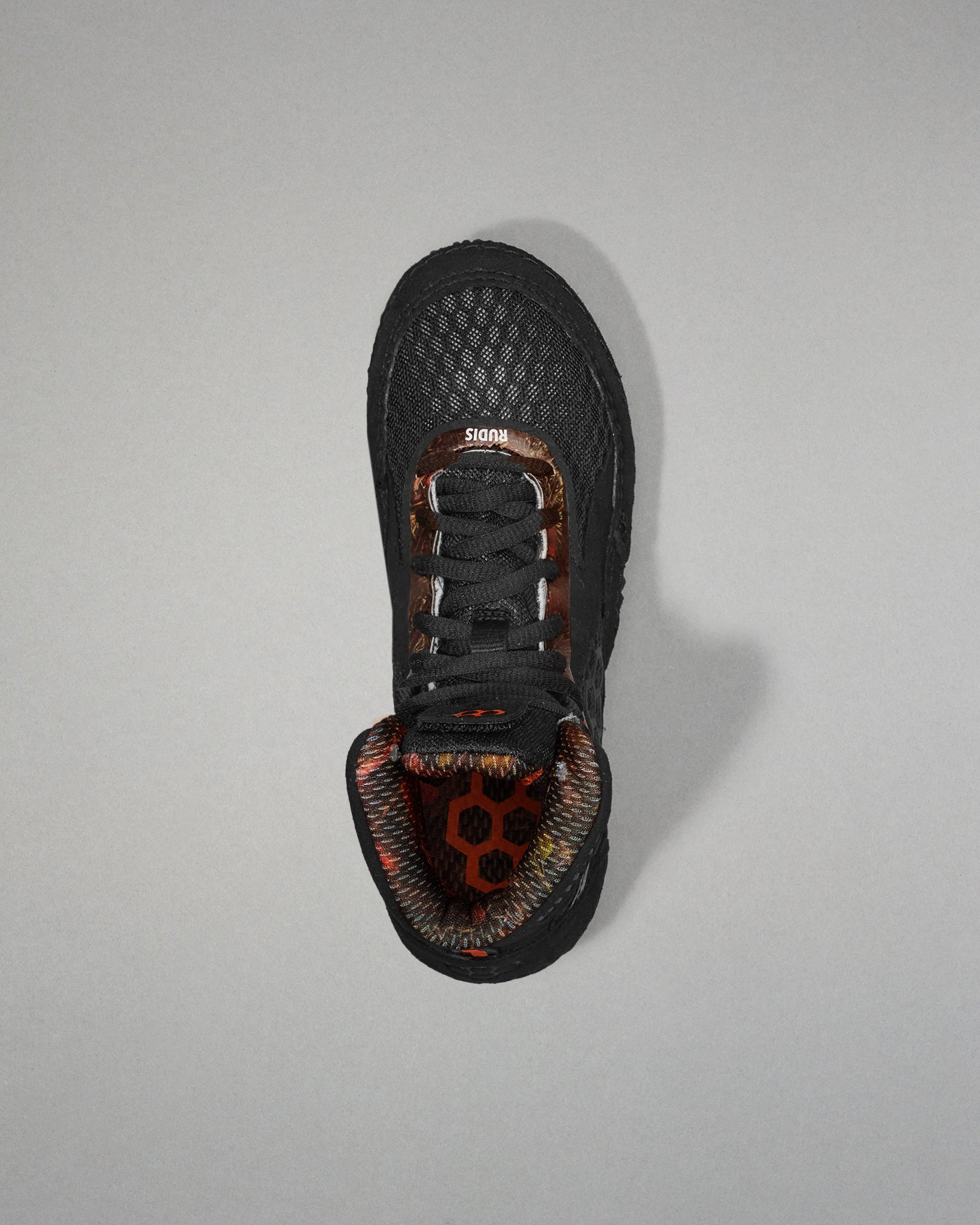 Black sneaker with a unique sole design on a gray background