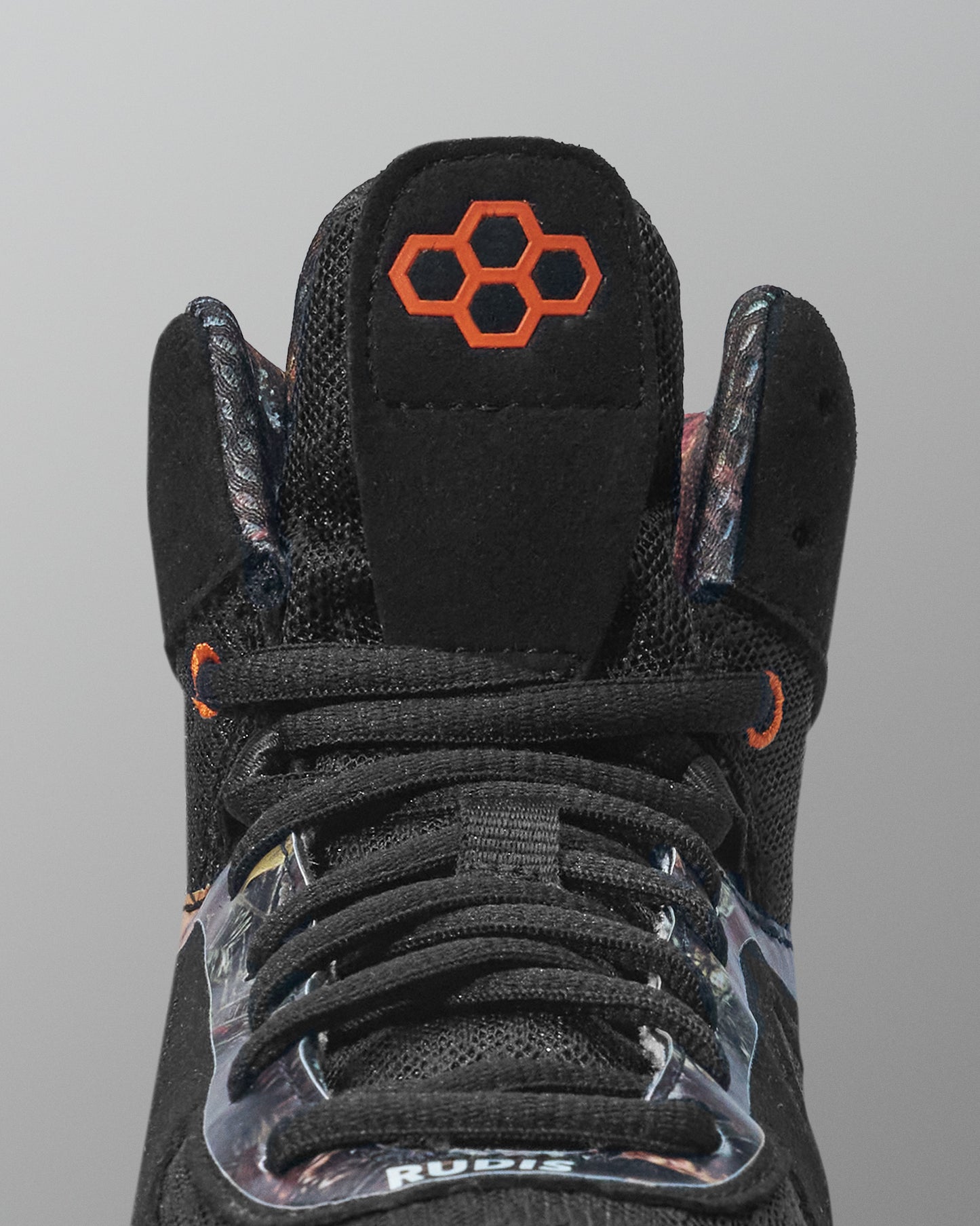 Black wrestling shoe with orange logo on a gray background