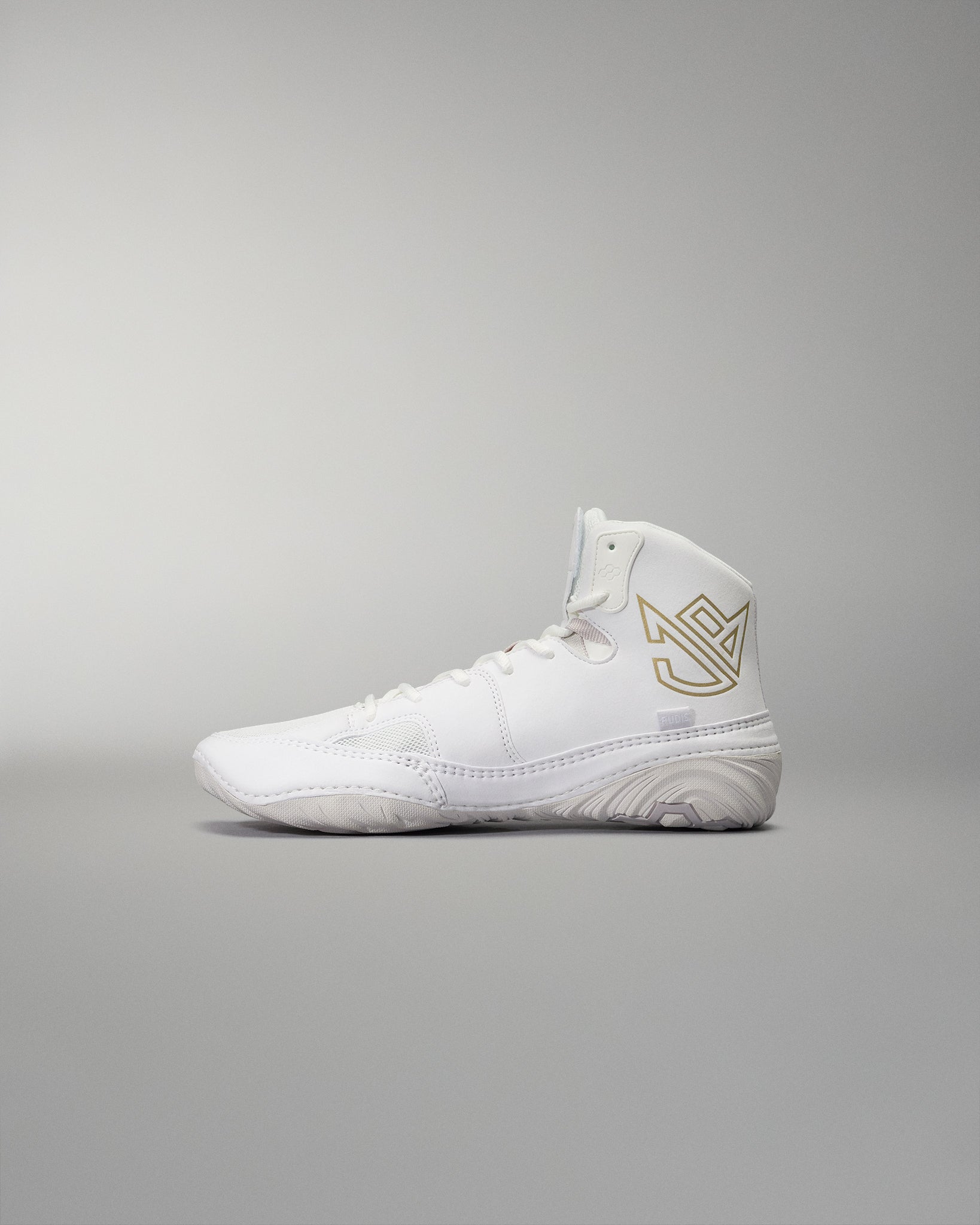 White high-top athletic shoe with smooth design, gold logo detail, and textured sole for grip against a soft gray background.