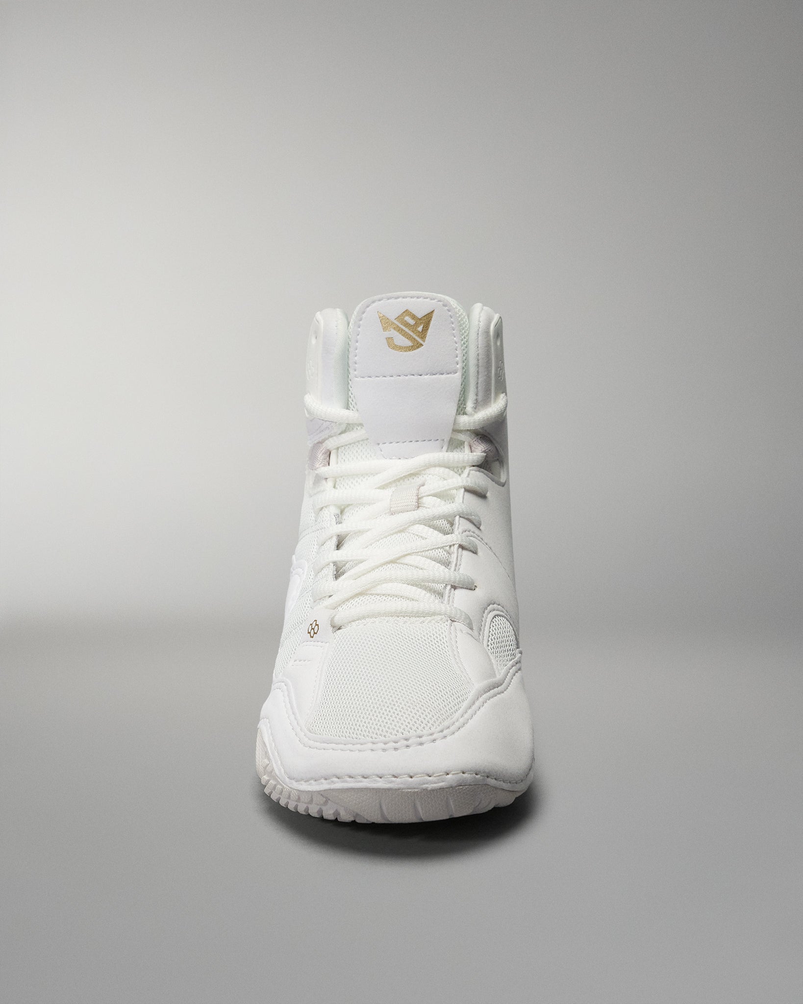 A high-top athletic shoe in white showcases a simple design with a gold logo on the tongue, set against a gradient background.