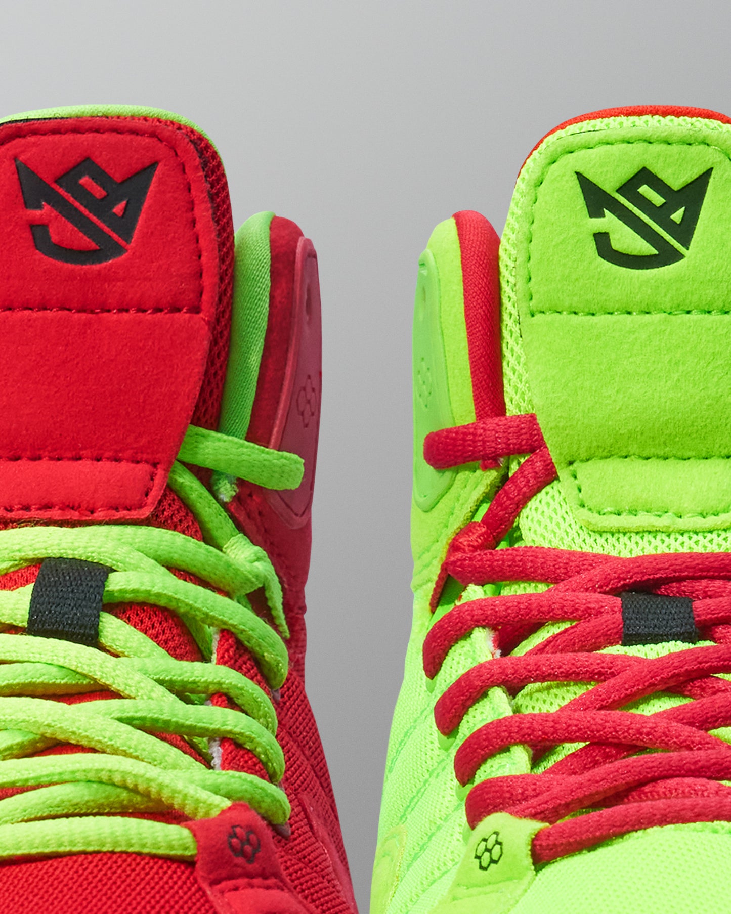 Close-up of red and green Wrestling shoes with brand logo on a gray background