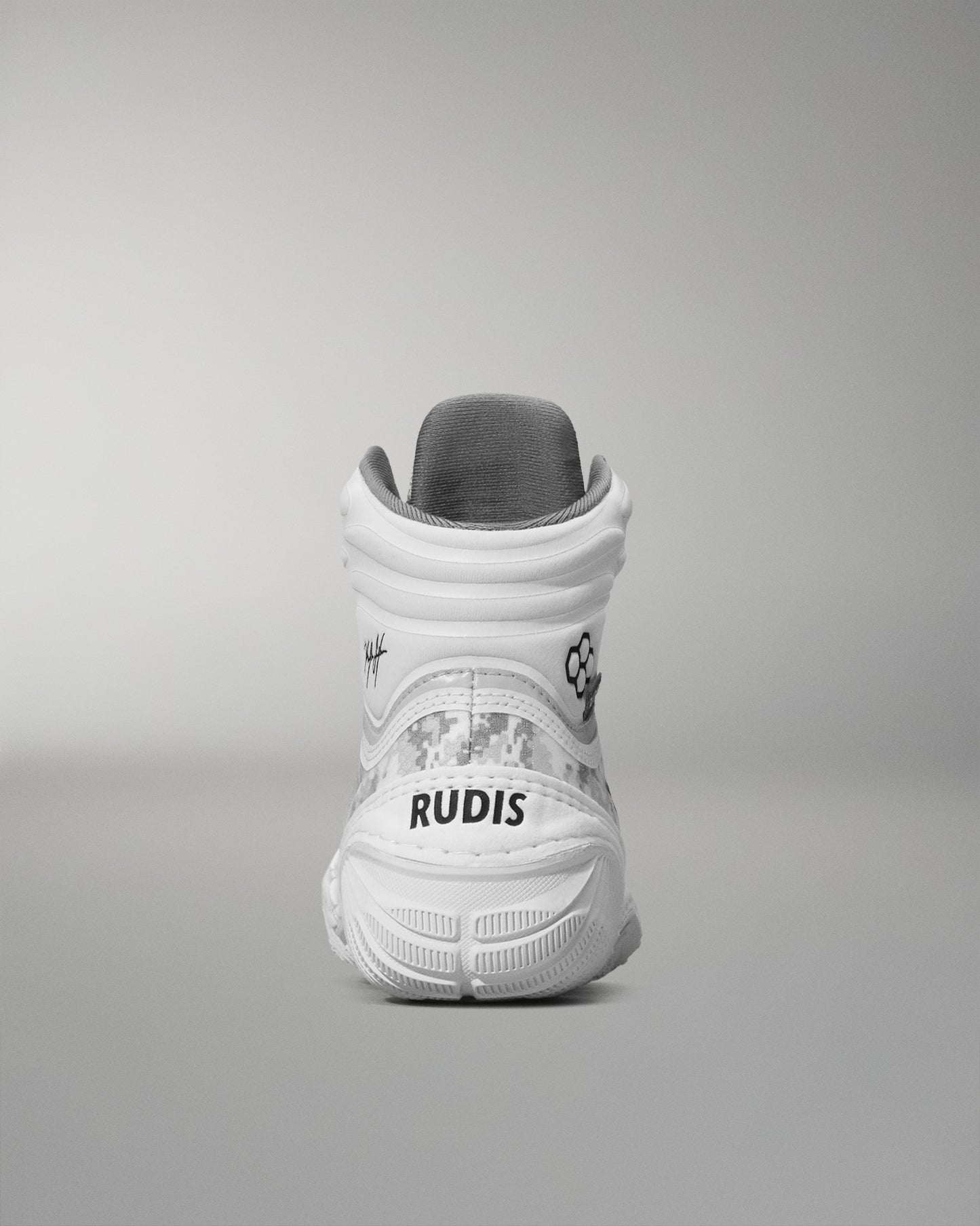 White wrestling shoe with 'RUDIS' branding on a gray background