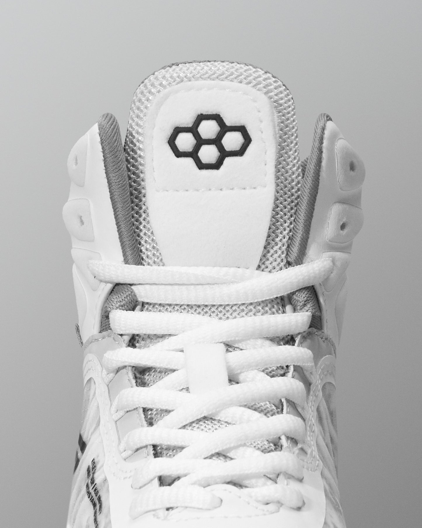 White wrestling shoe with a brand logo on a gray background