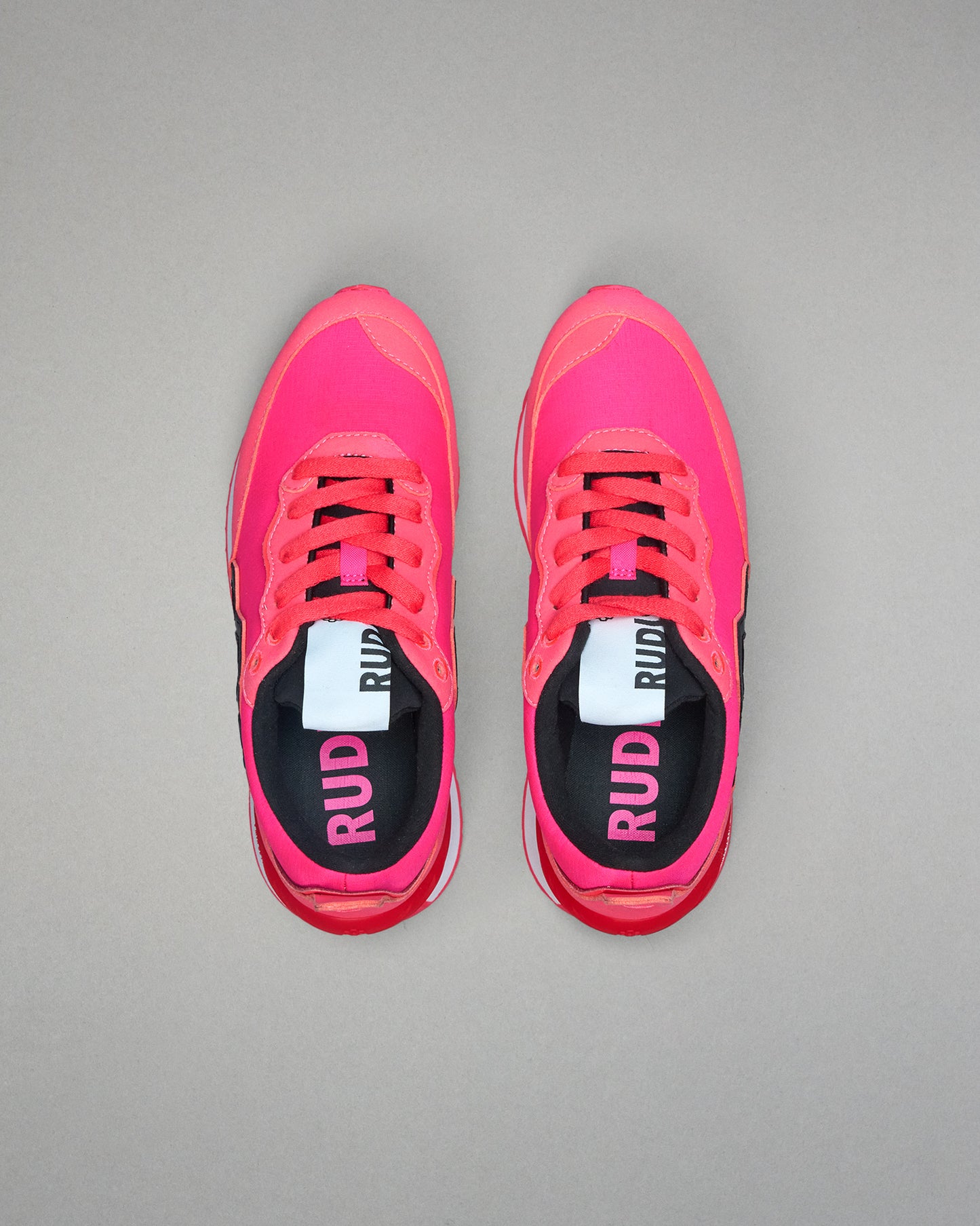 Pair of pink running shoes with 'RUD' branding on a gray background
