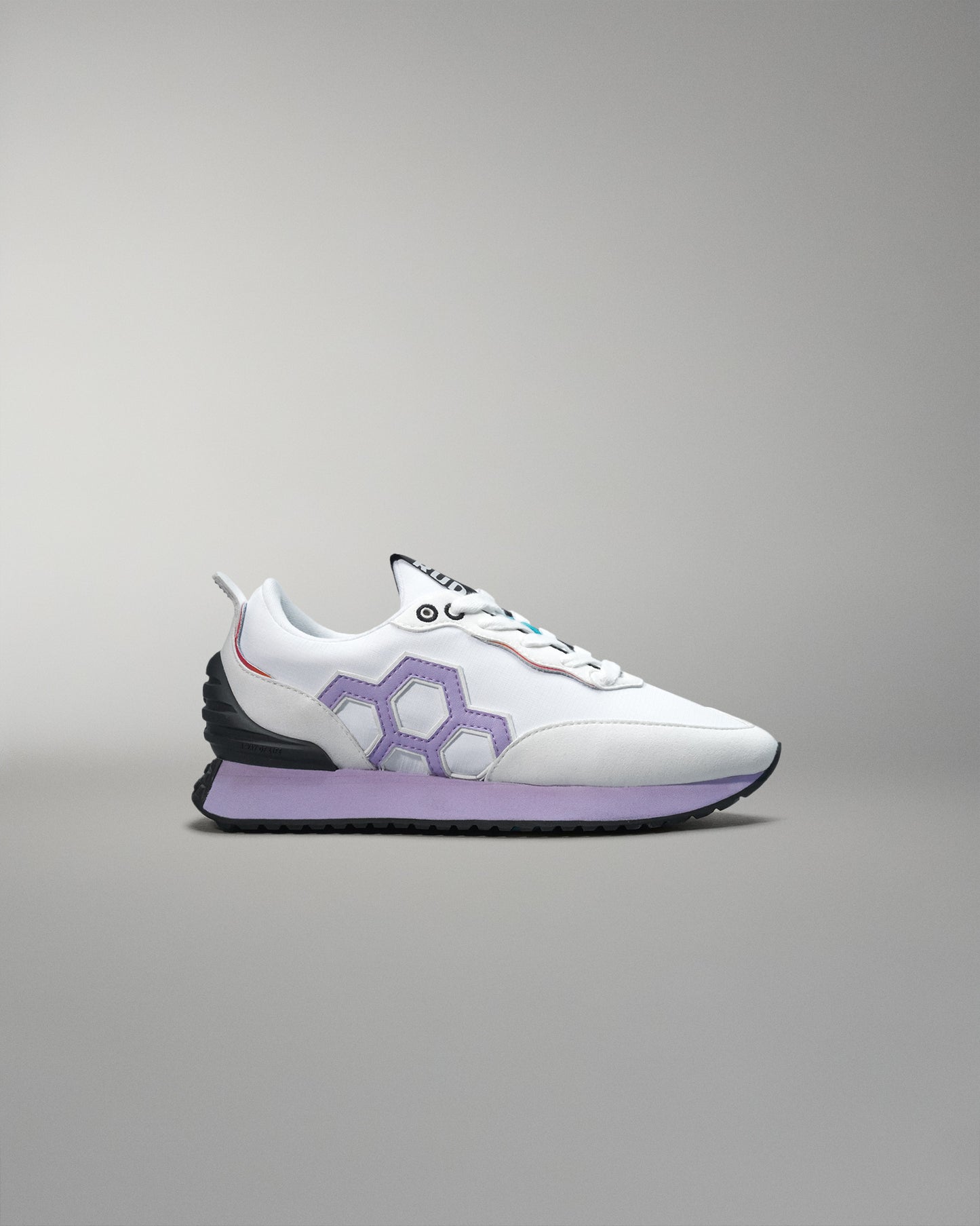 White and purple sneaker on a gray background