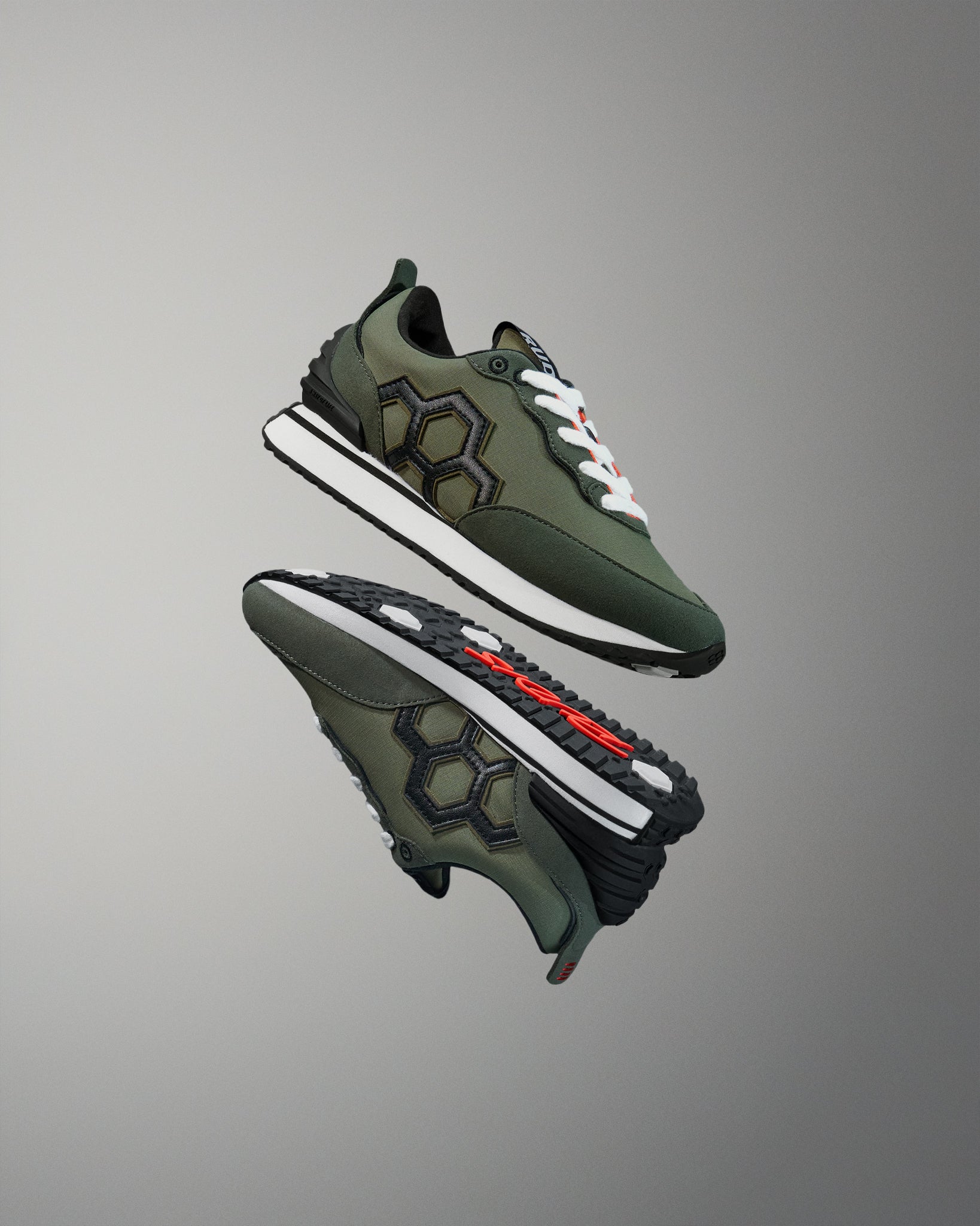 Green sneakers with white soles on a gray background