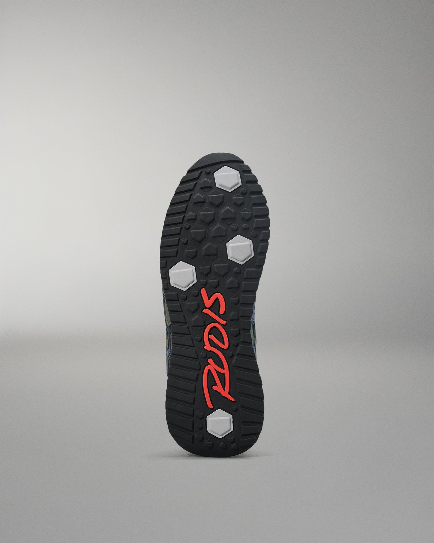 Black shoe sole with red branding on a gray background