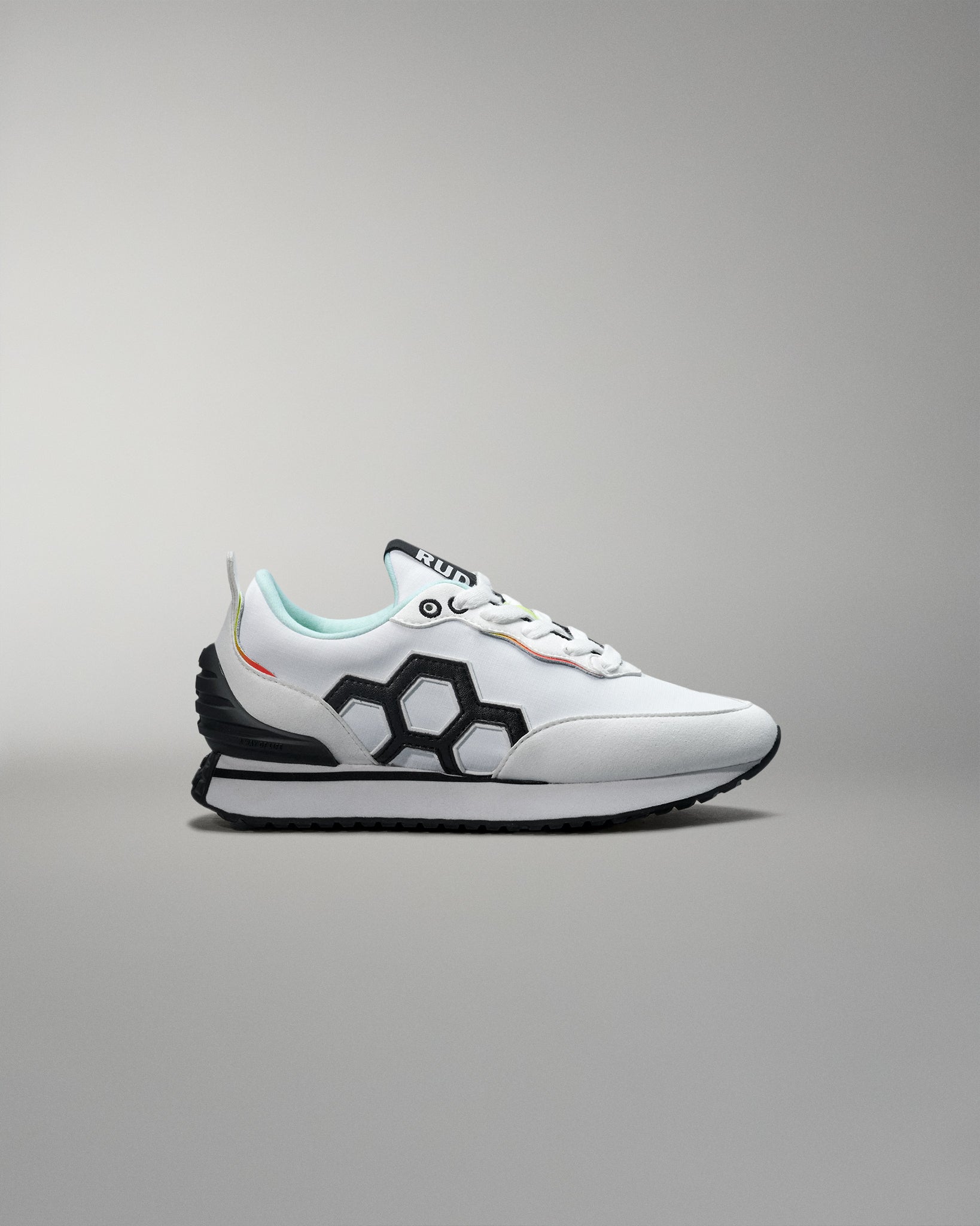 White sneaker with black and red accents on a gray background