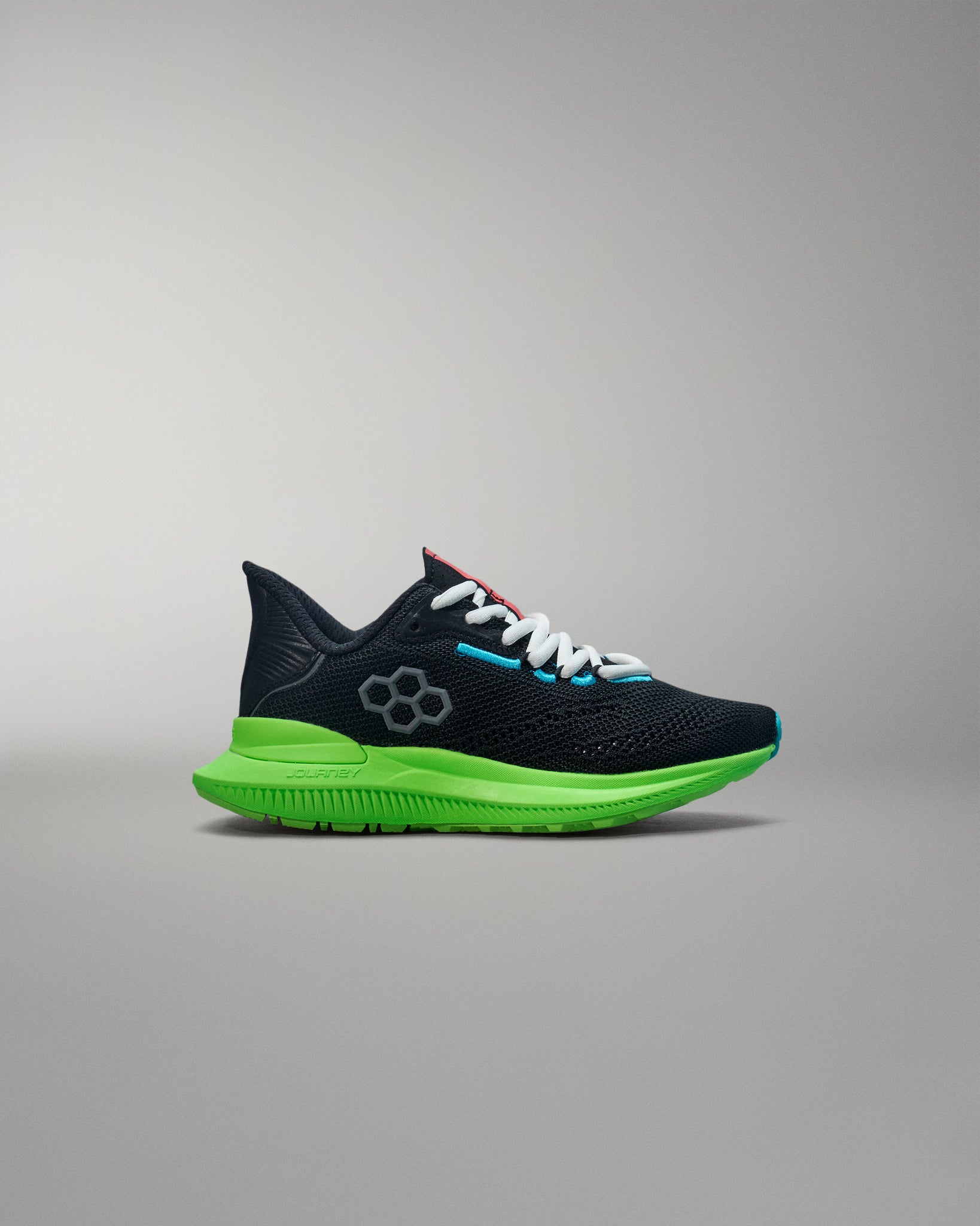 Black and green running shoe on a gray background