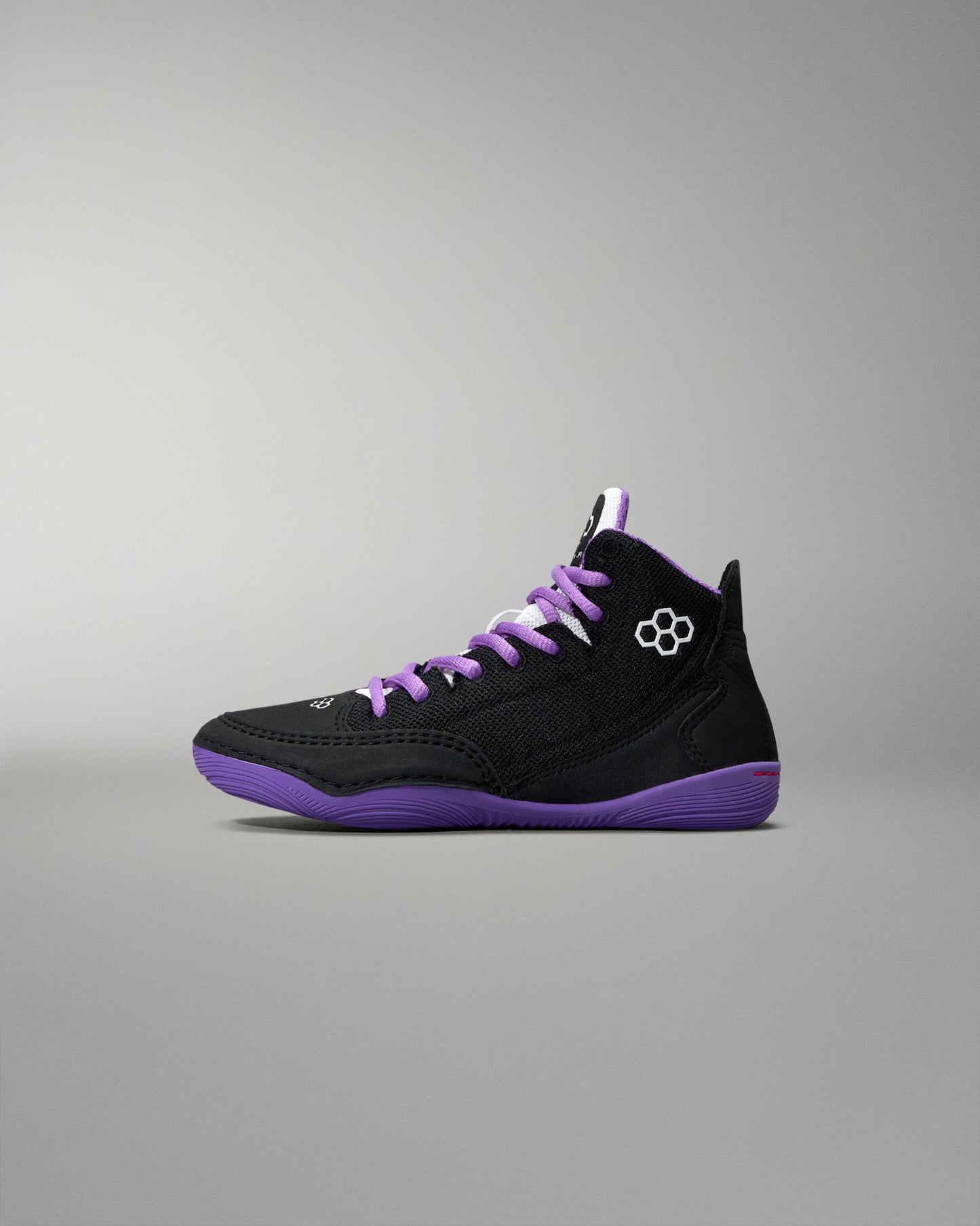 Black and purple sneaker with a brand logo on a gray background