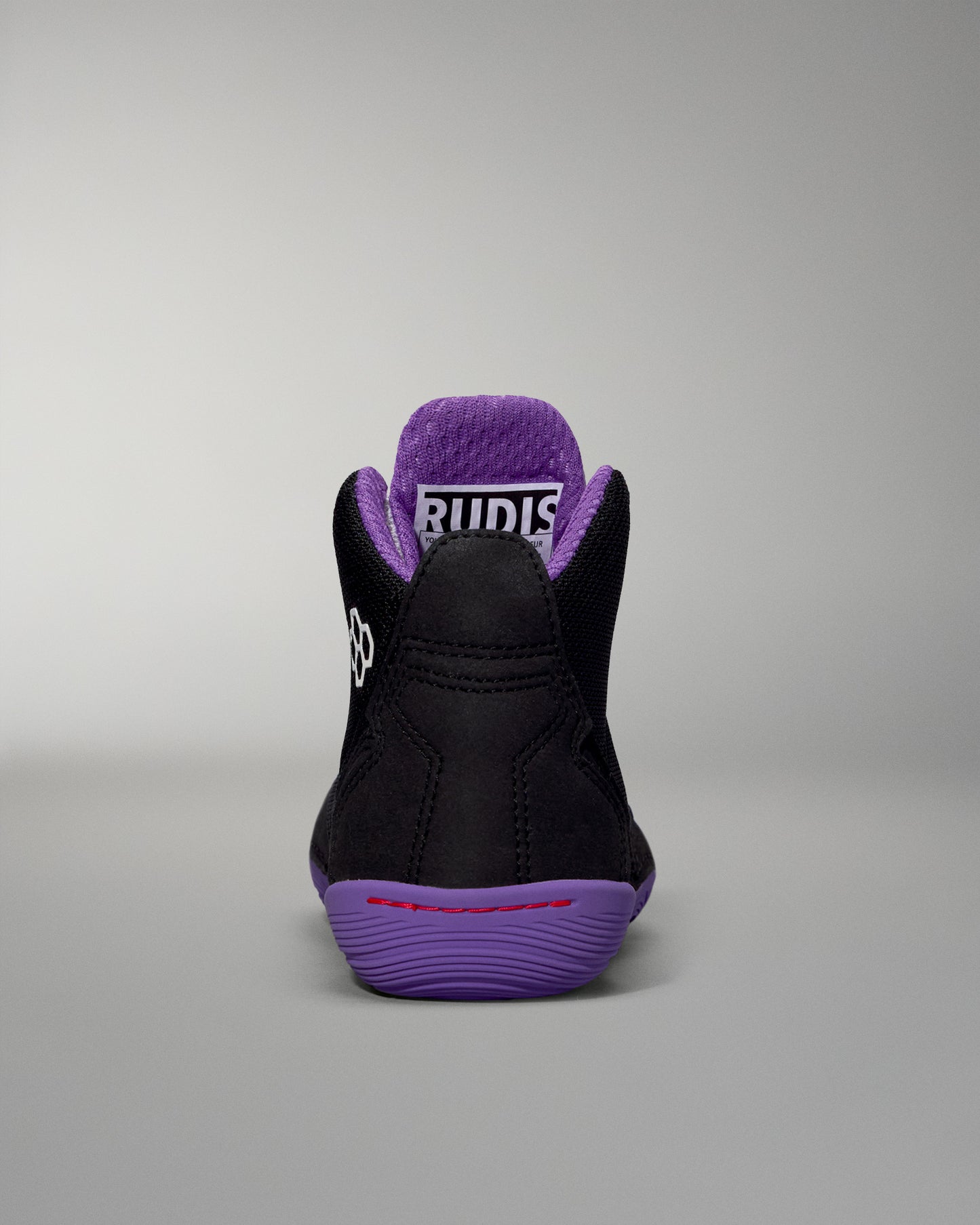 Black and purple sneaker with visible brand logo on a gray background