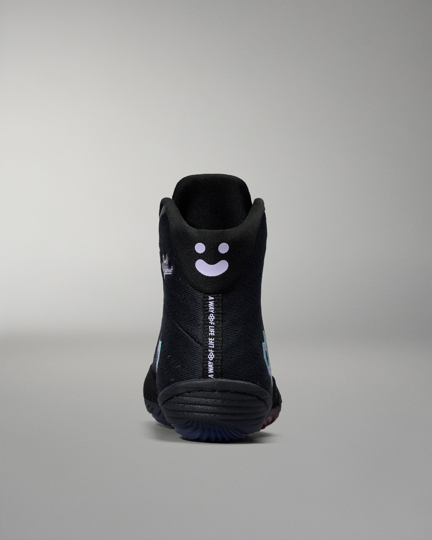 Black high-top sneaker with a smiley face design on a gray background