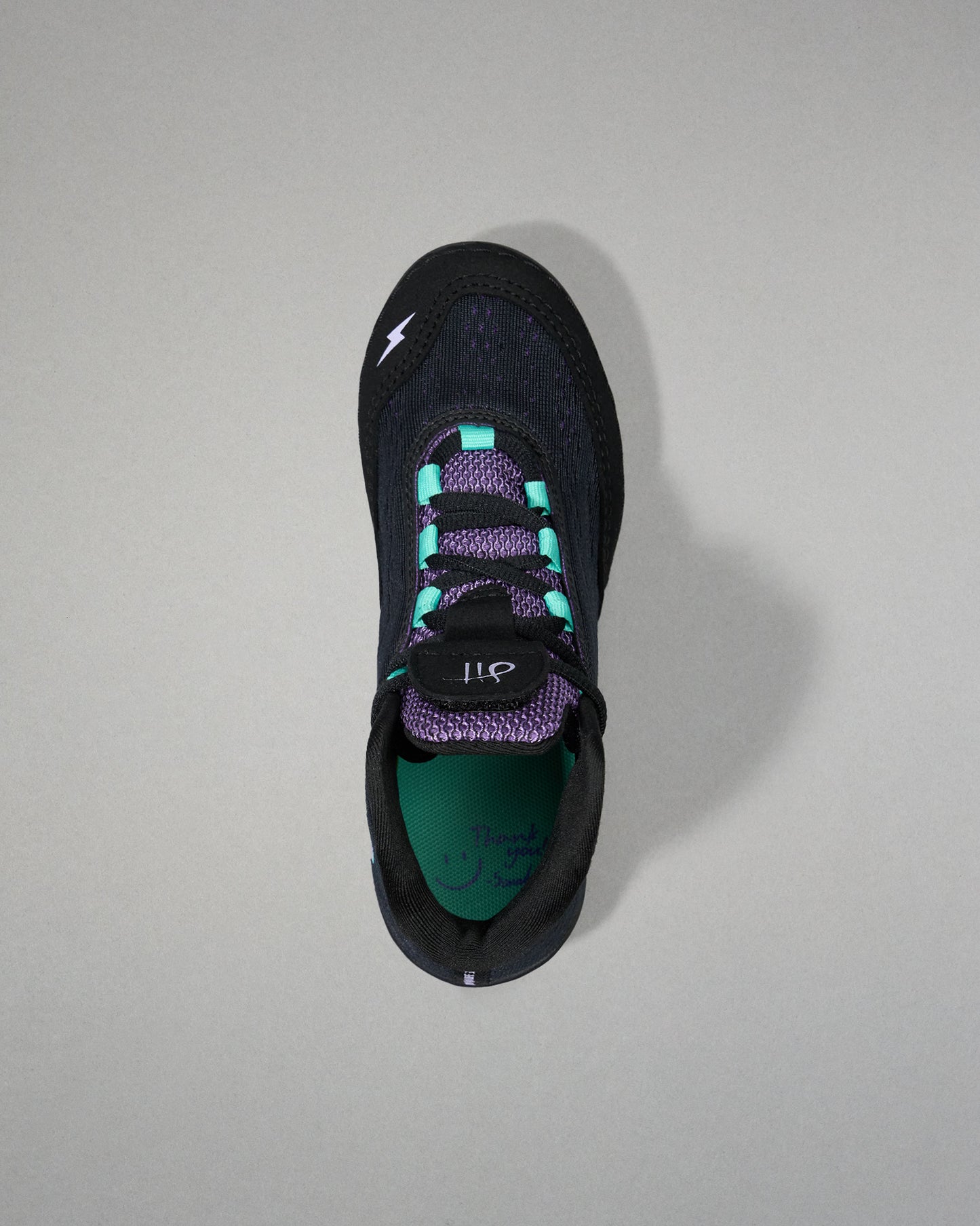 Black sneaker with purple accents on a gray background