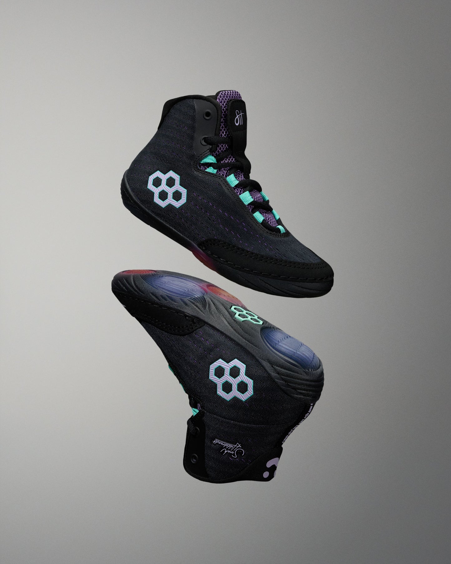 Black high-top wrestling shoes with a unique design on a gray background