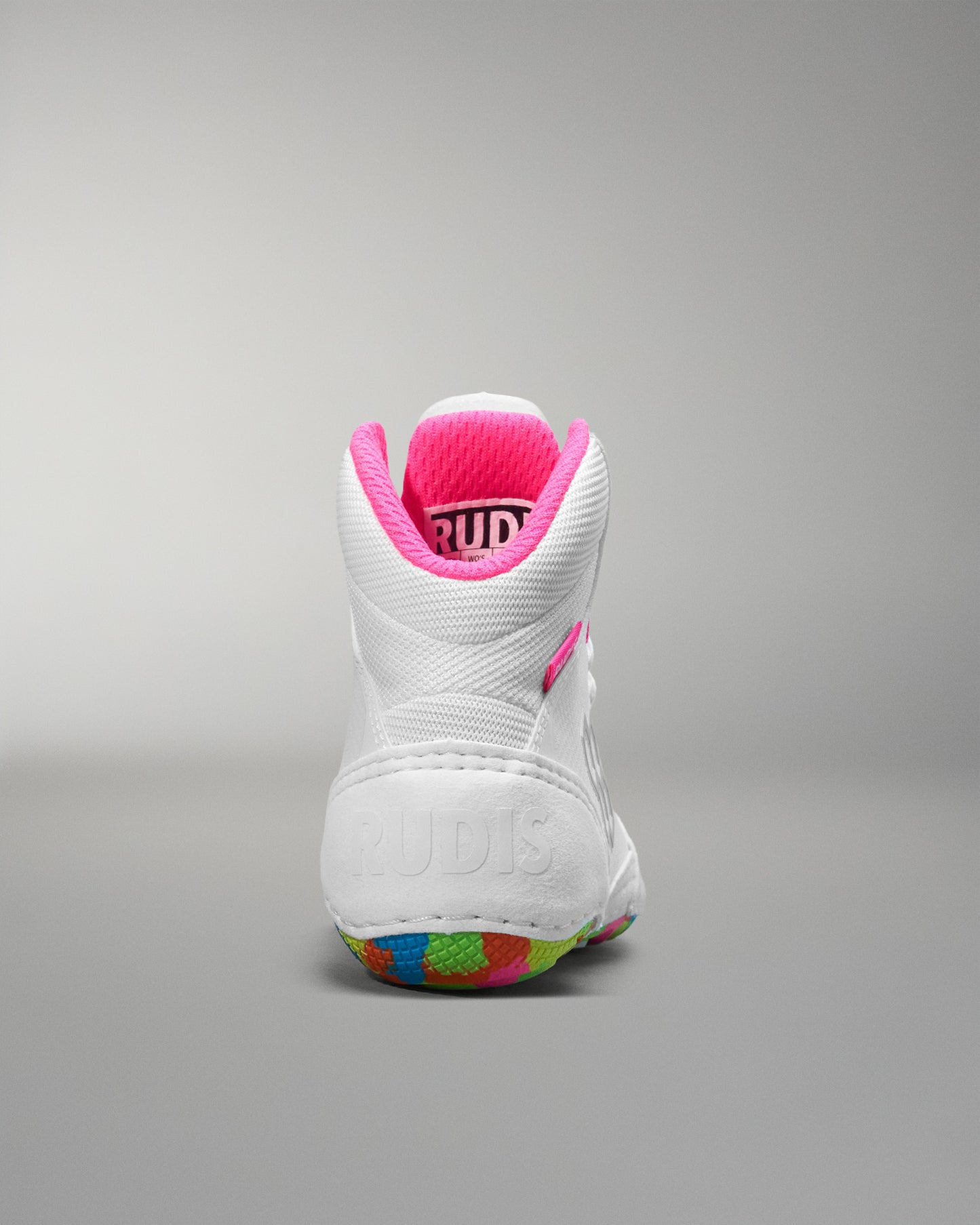 White wrestling shoe with pink interior on a gray background