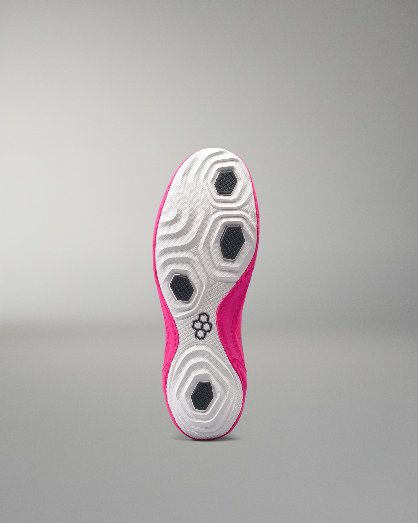 Sole of a pink and white athletic shoe on a gray background