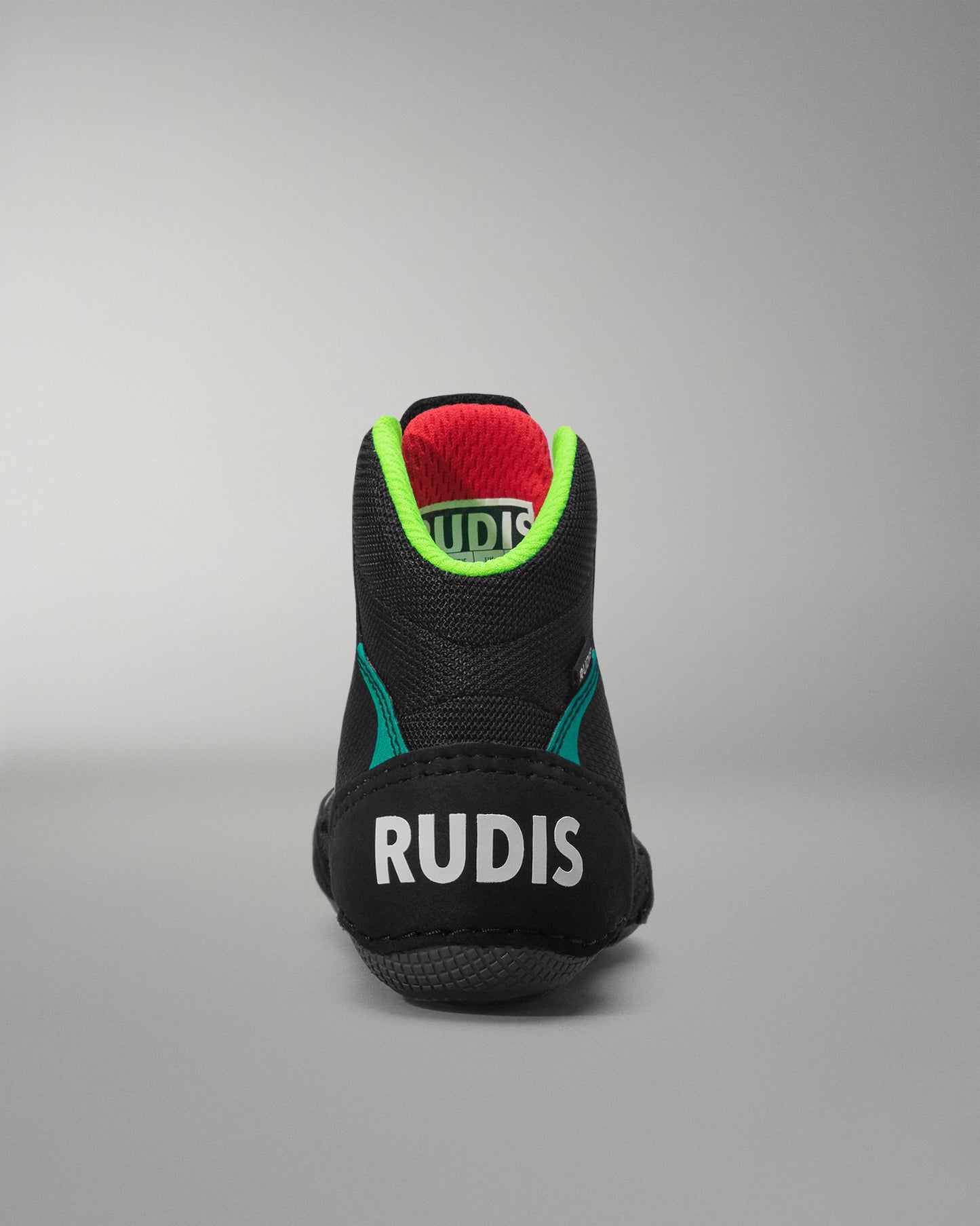 Black wrestling shoe with 'RUDIS' branding on a gray background
