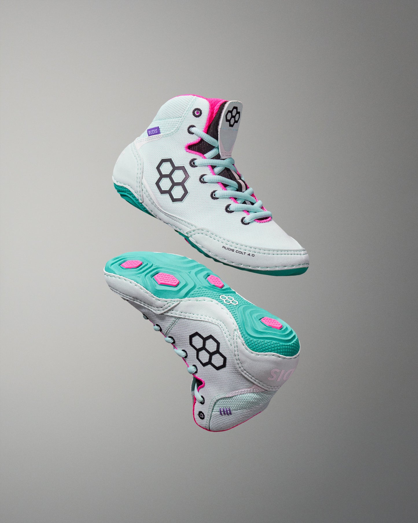 Pair of white and teal sneakers with pink accents on a gray background