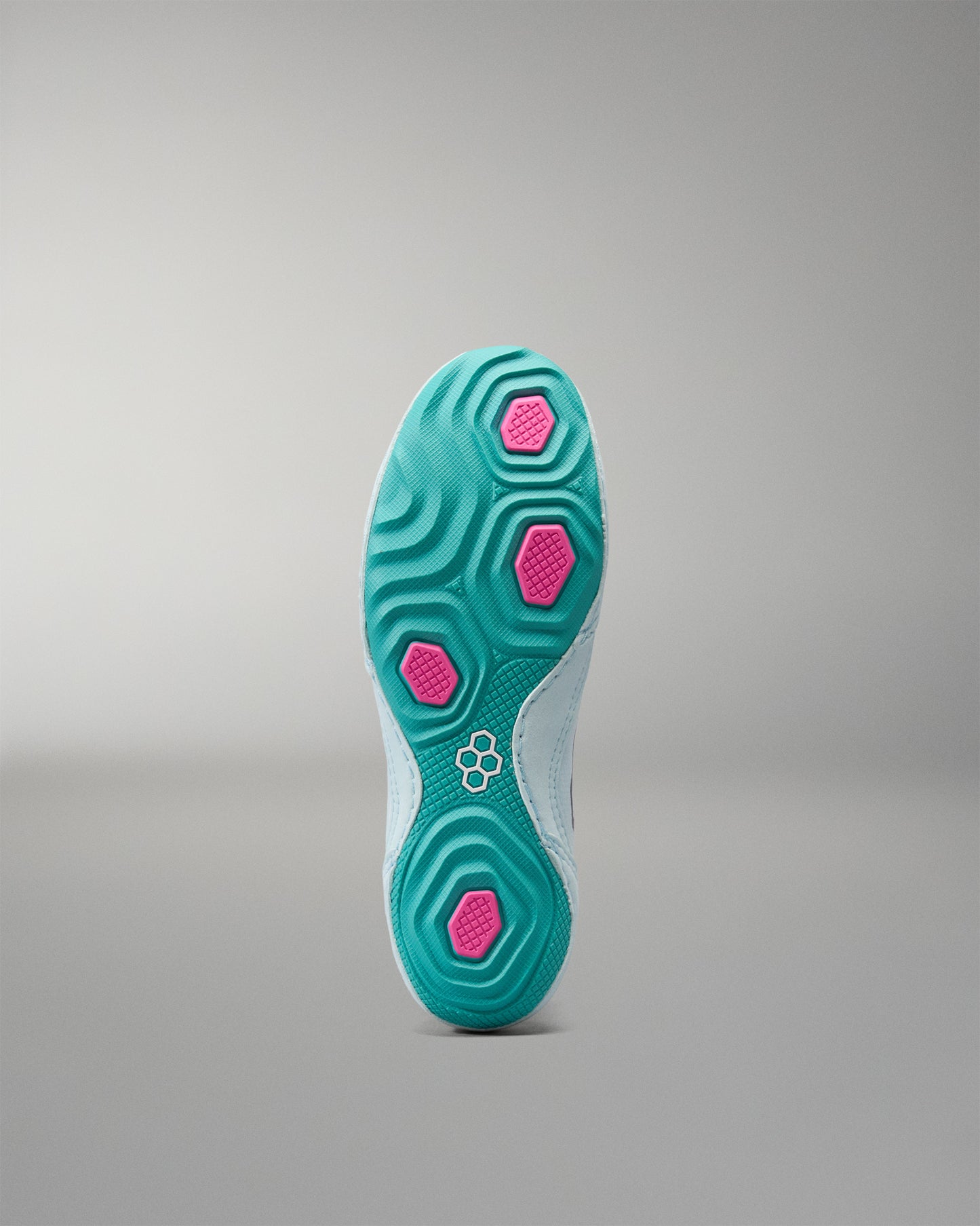 Teal shoe sole with pink accents on a gray background
